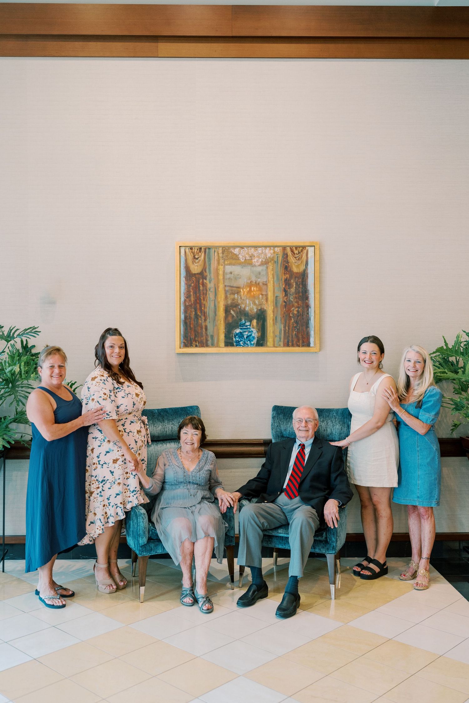 Family members arranged in creative sitting poses along lobby wall.