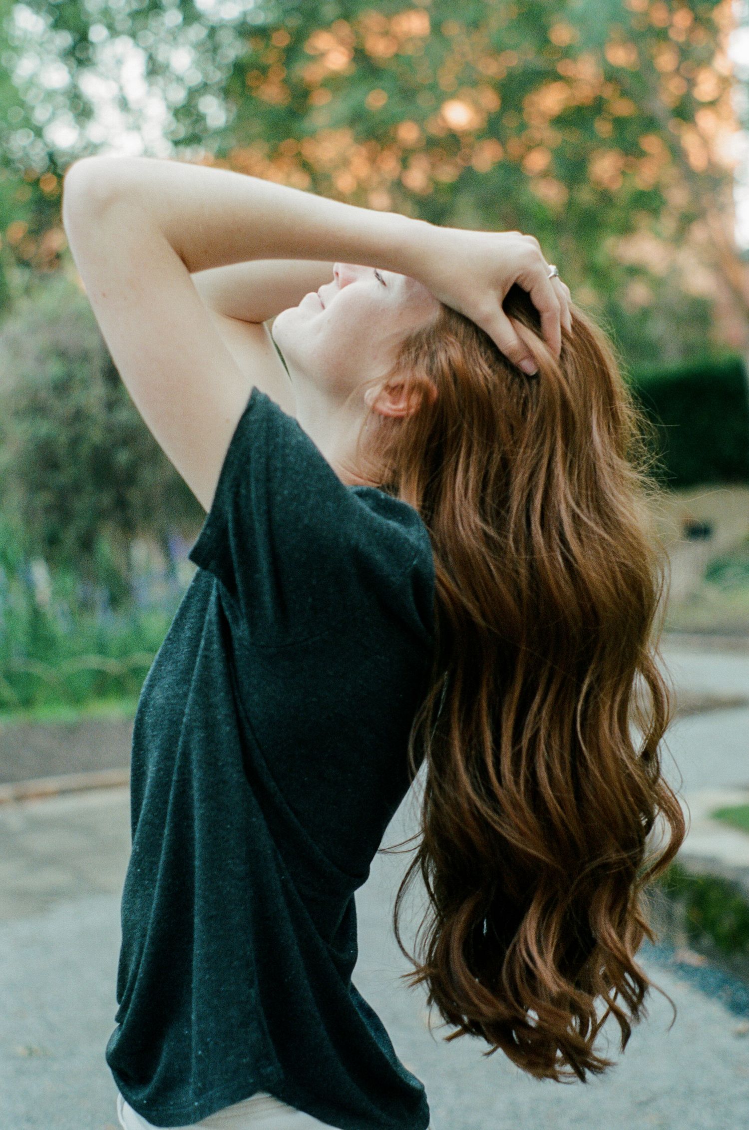 Artistic movement shots with dramatic hair motion against natural outdoor backdrop.