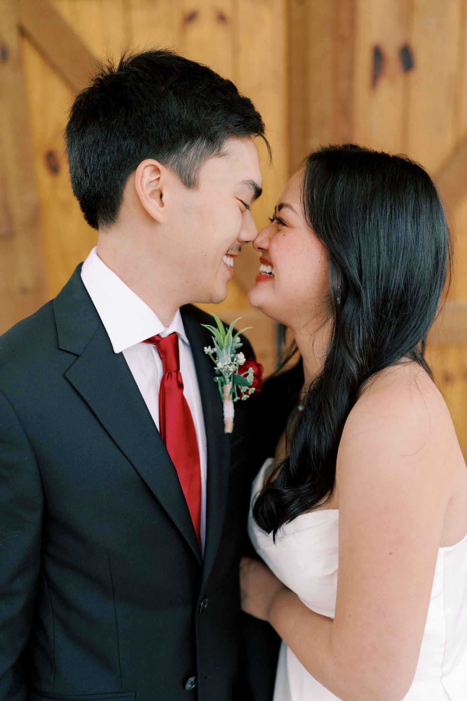 Intimate wedding portraits captured against wooden barn backdrop showing tender moments.