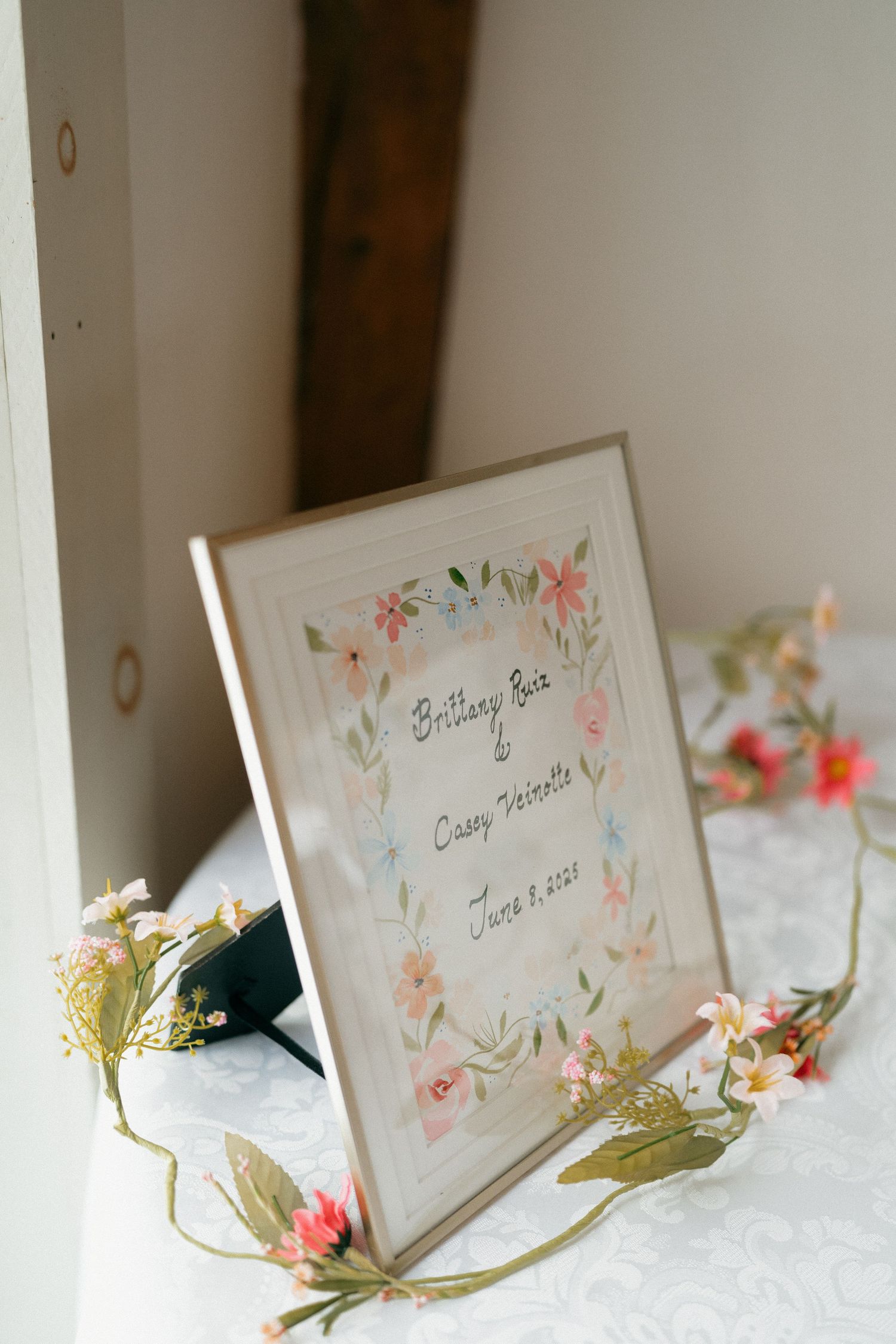 Wedding place cards with floral watercolor designs displayed on a white tablecloth.