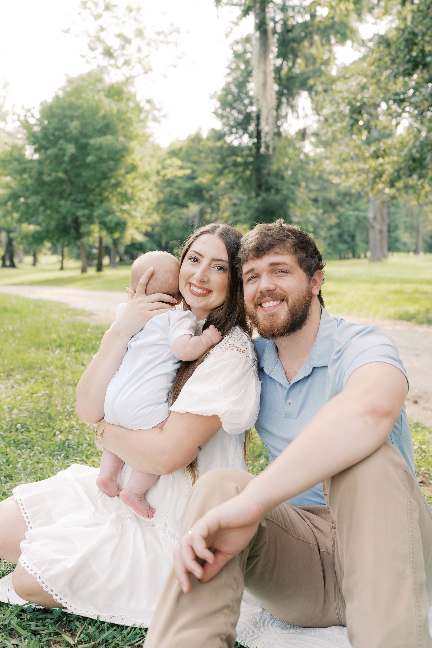 Sweet family moment captured in a park with everyone sitting close together on the grass.