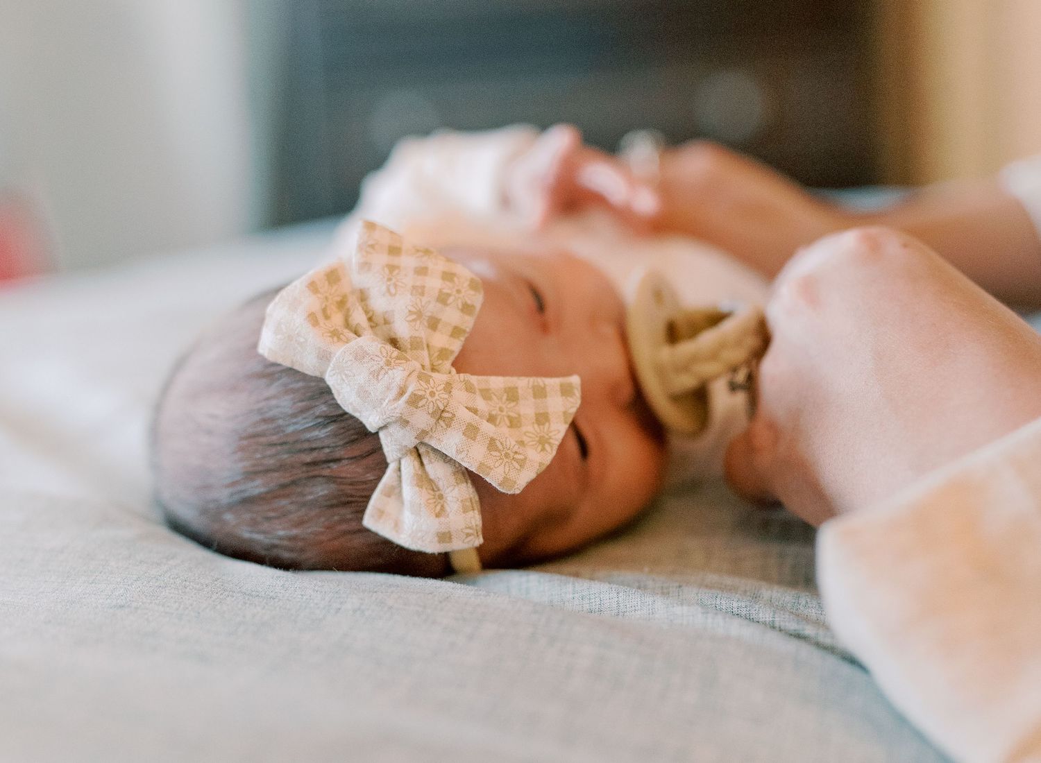 Gentle close-up portrait on textured fabric with soft lighting.