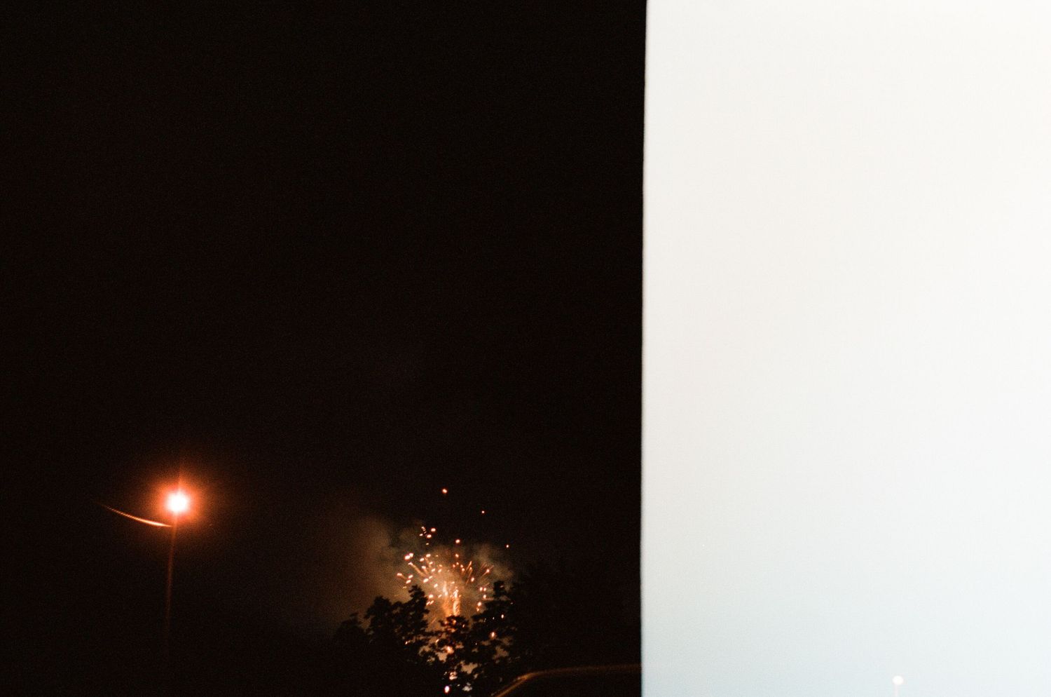 Series of bright lights against a dark night sky creating a glowing effect.