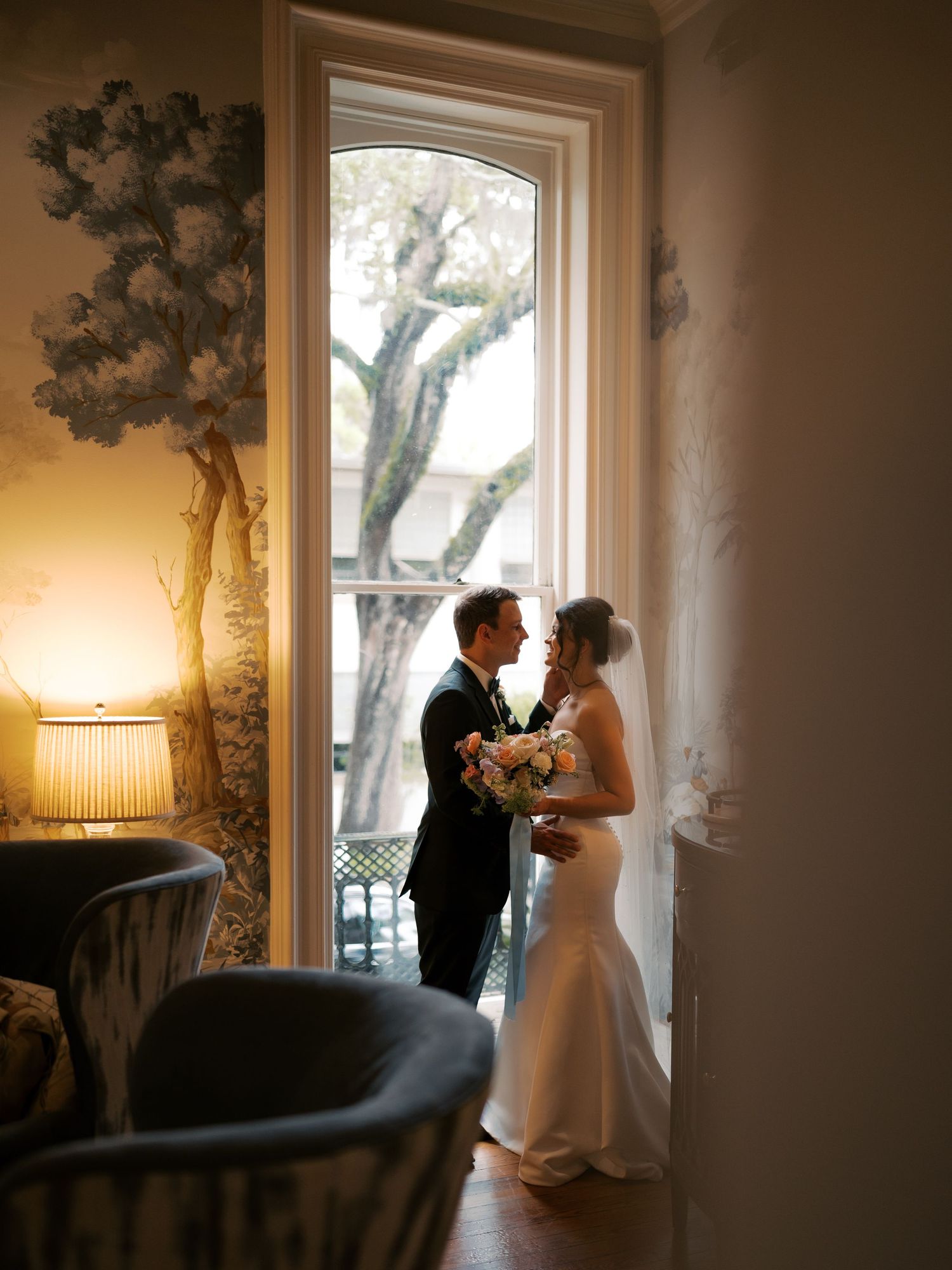 Intimate wedding moments captured in a warmly lit room with large windows.