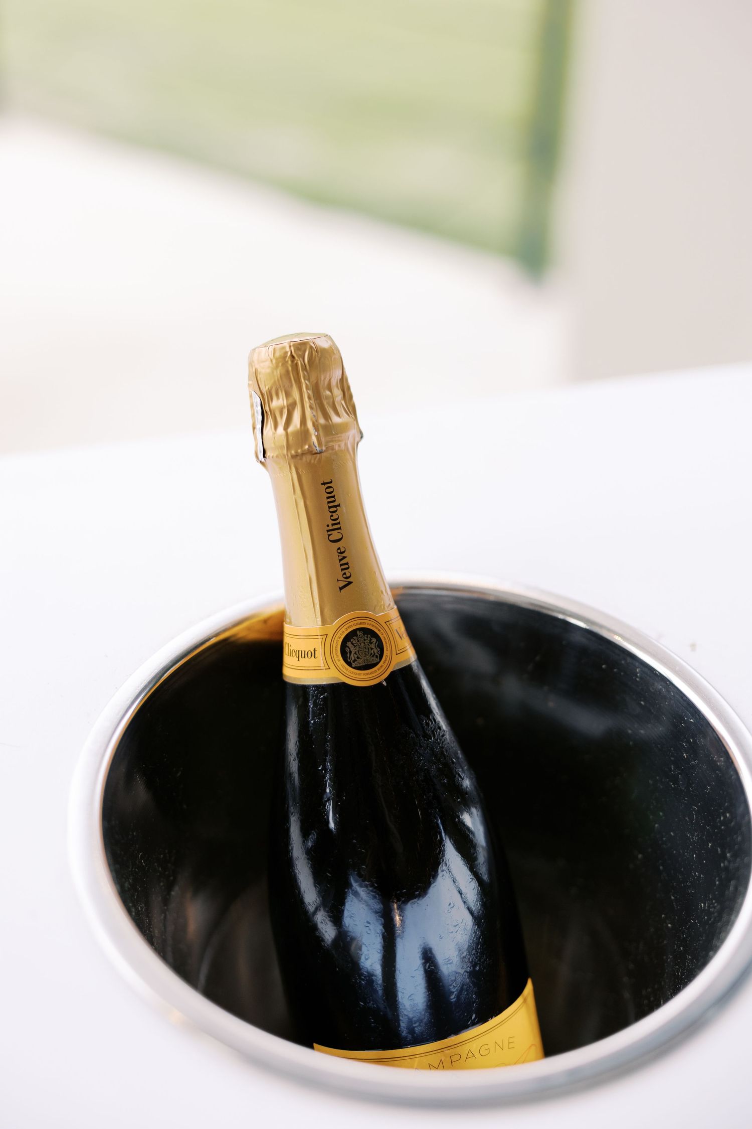 Champagne bottle chilling in black ice bucket at wedding reception.