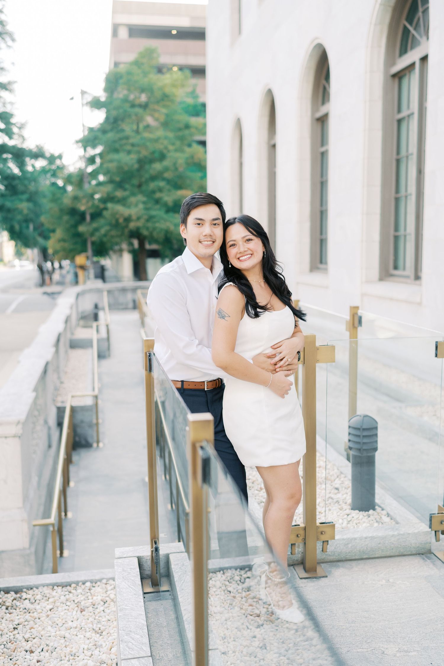 Couple sharing playful moments together on an outdoor architectural walkway.