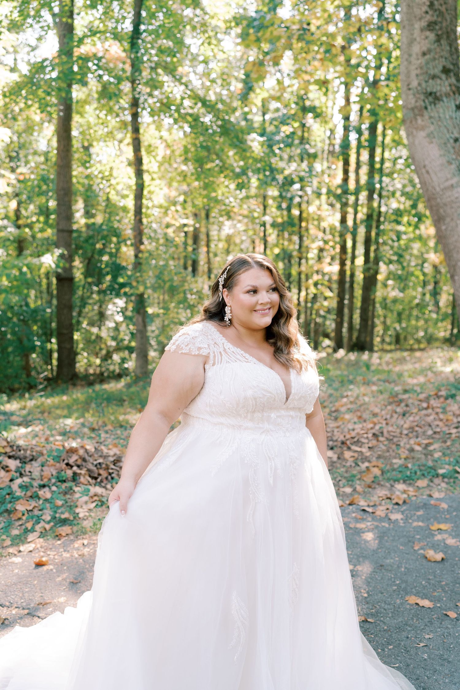 White wedding gown with delicate lace details captured in forest setting.