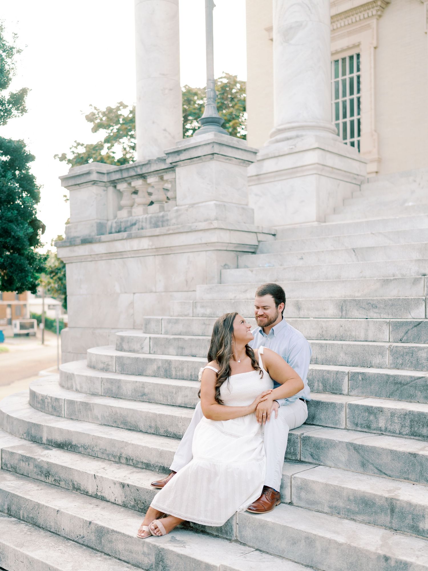 A romantic couple photo session on elegant white stone steps of a historic building.
