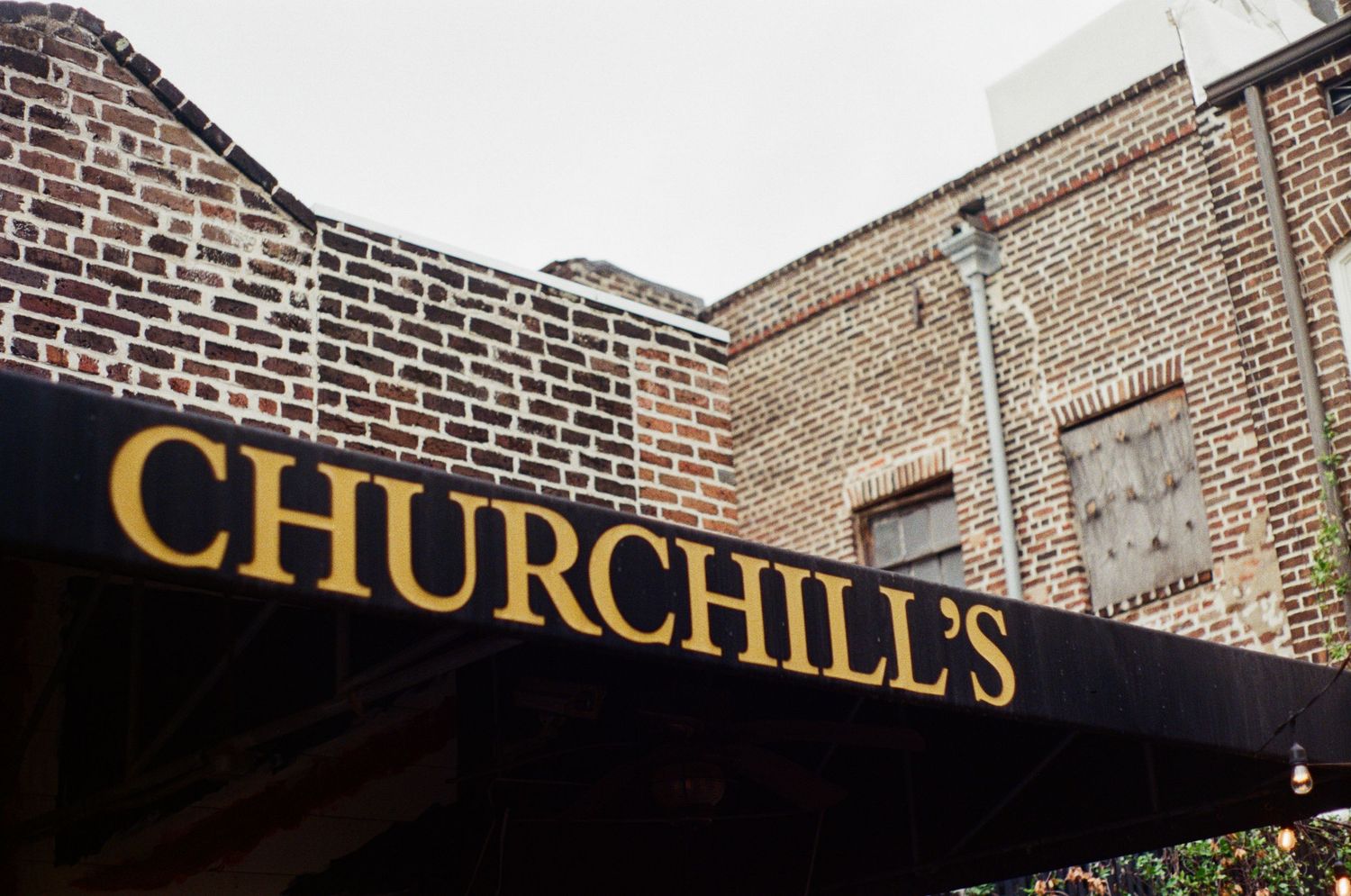 Brick building exterior with gold lettering signage.