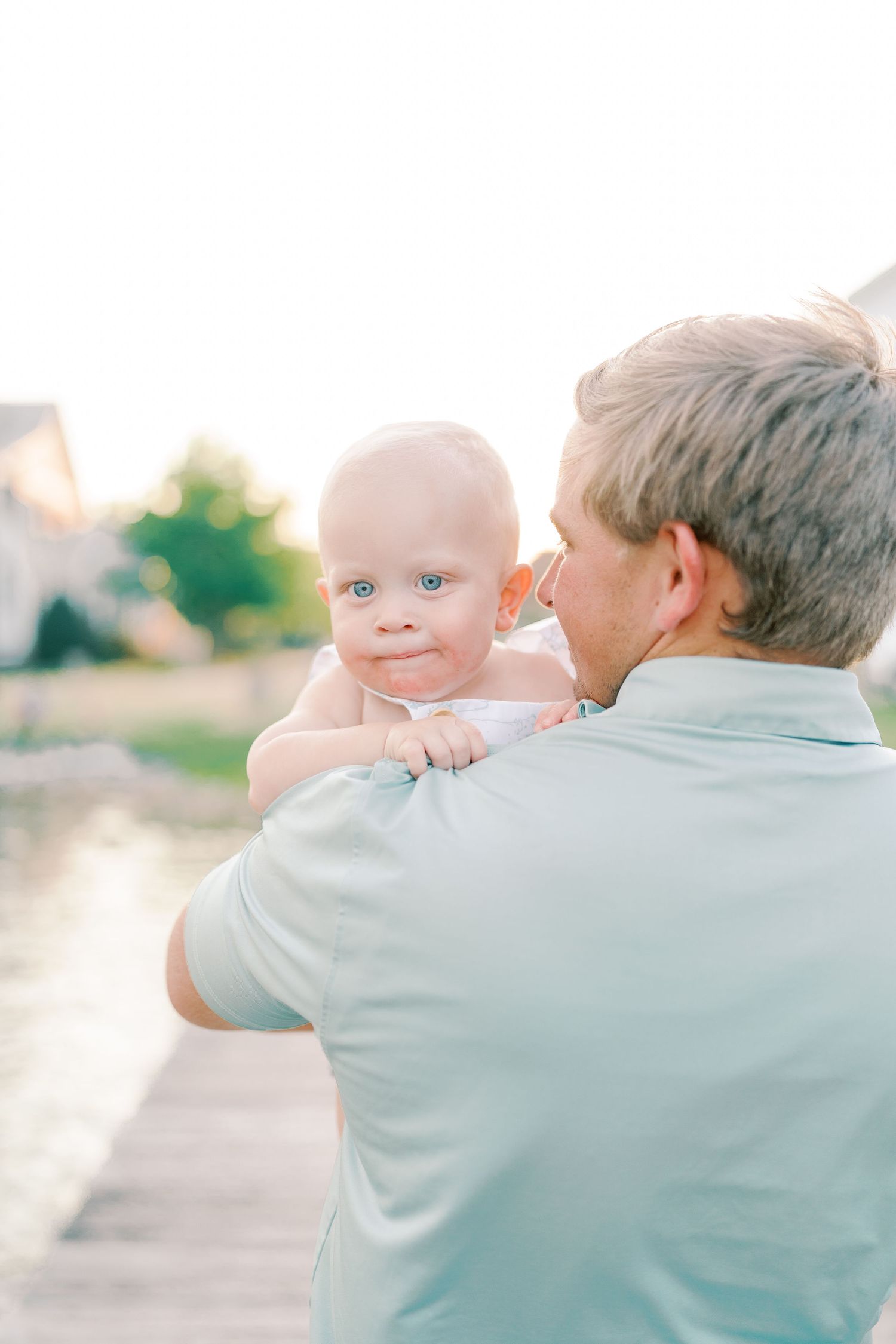 Sweet outdoor moment between family members on a sunny day by the water.