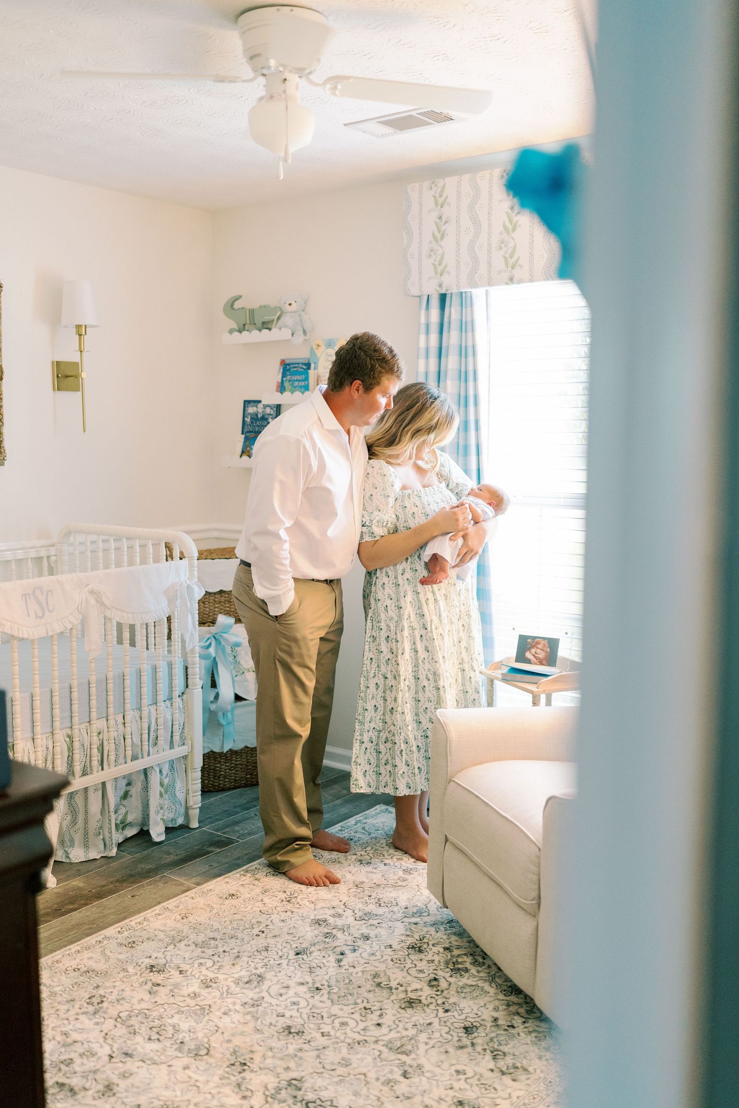 Sunlit nursery room featuring white furniture and blue accents.