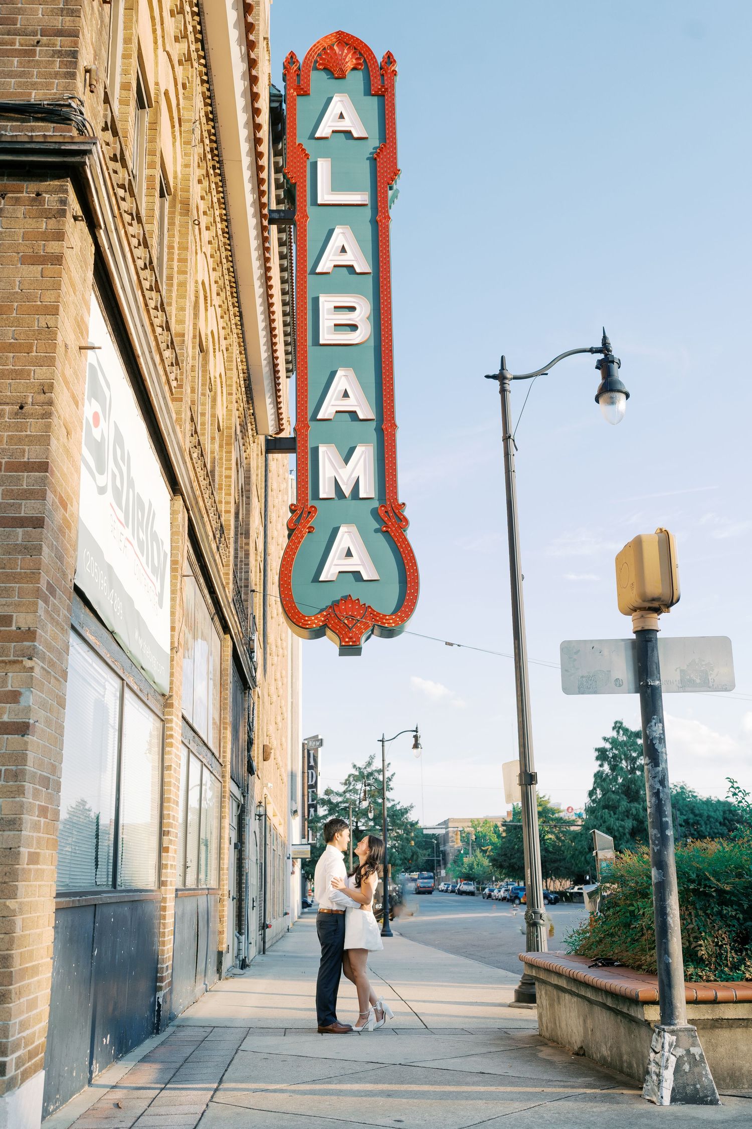Vintage theater sign and brick building facade under blue sky.