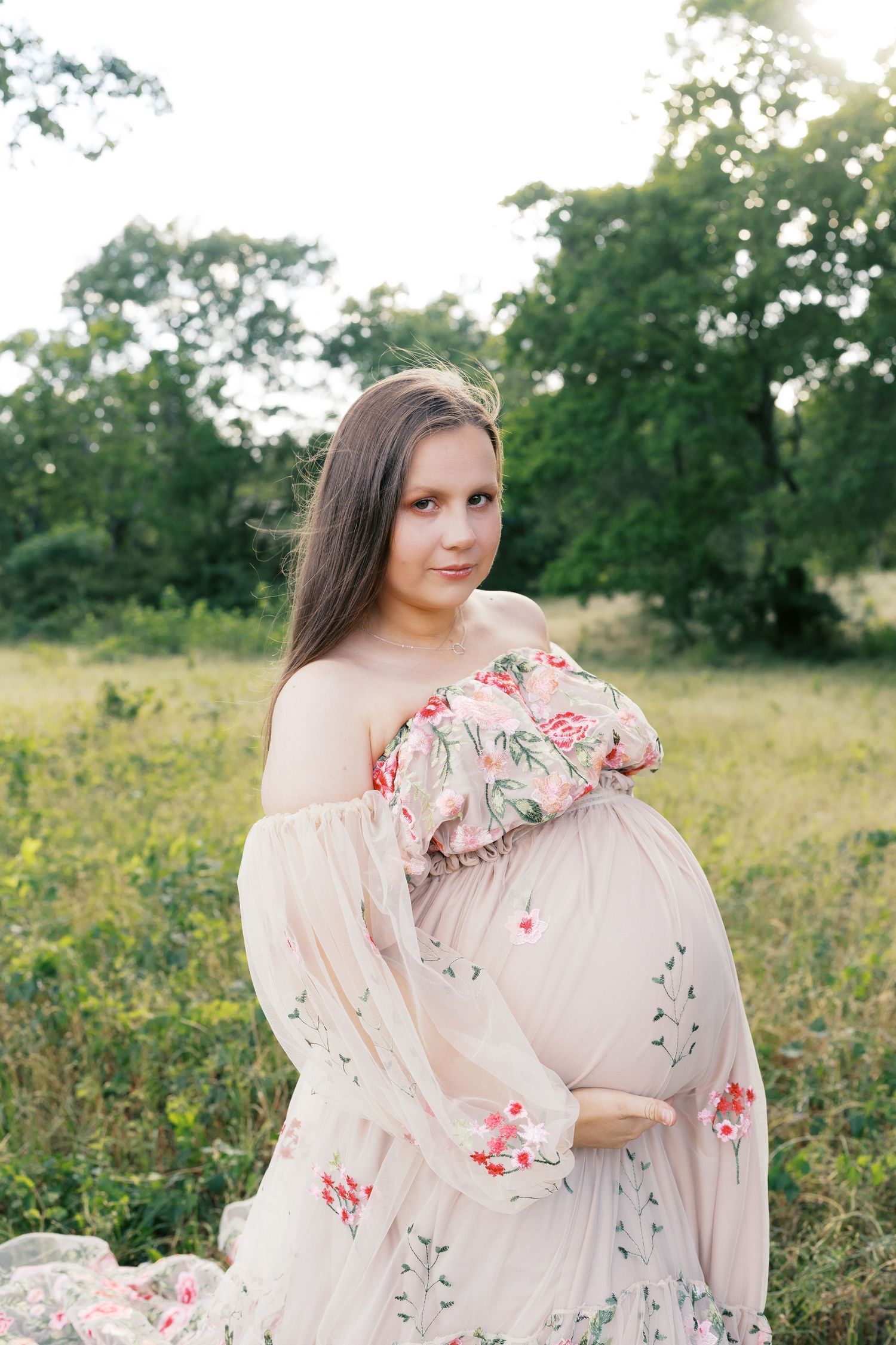 Romantic pink dress with floral details captured in a dreamy outdoor setting.