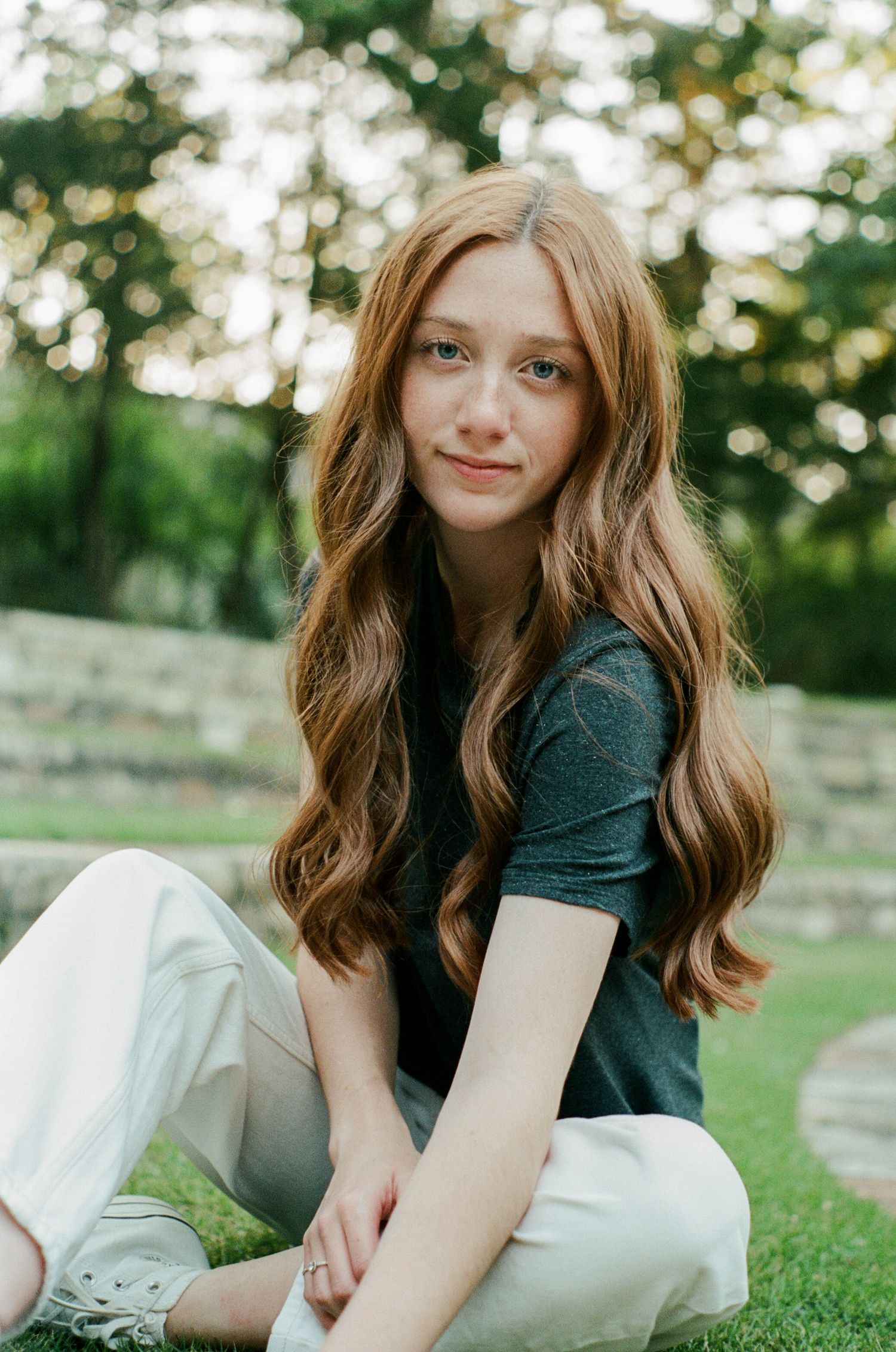Person in dark shirt lounging on green grass during golden hour.