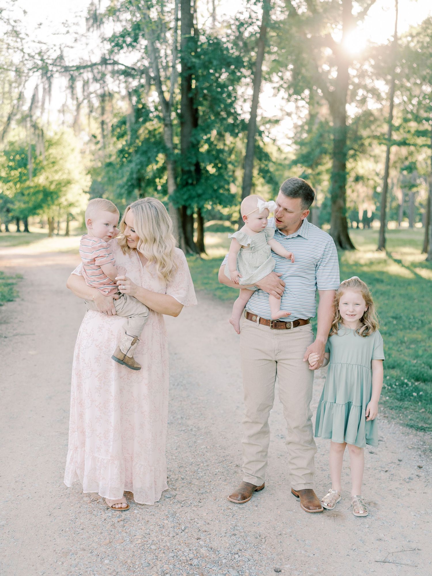 Candid family moments captured on a tree-lined path during golden hour.