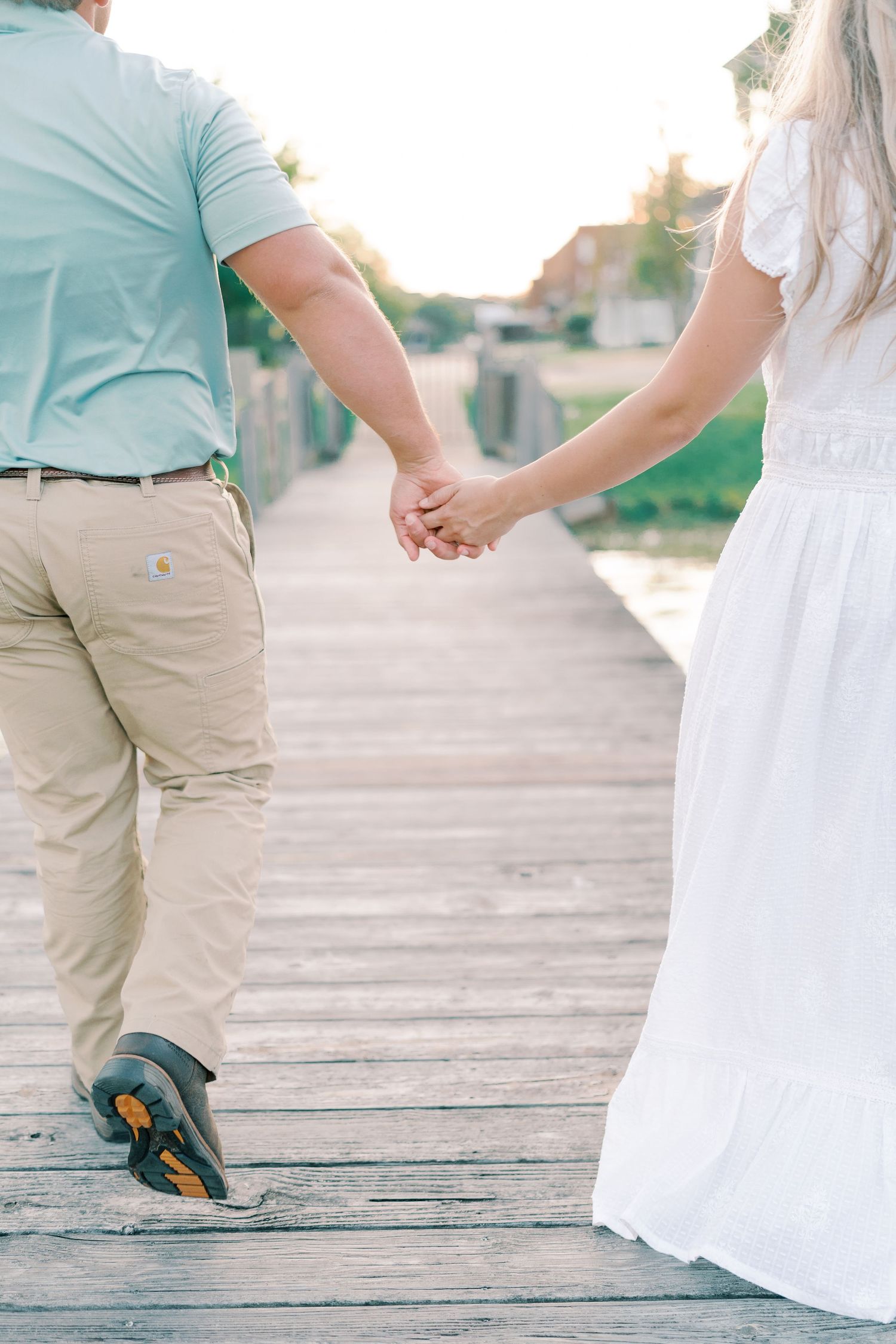 Close-up view of feet and legs on a rustic wooden dock.