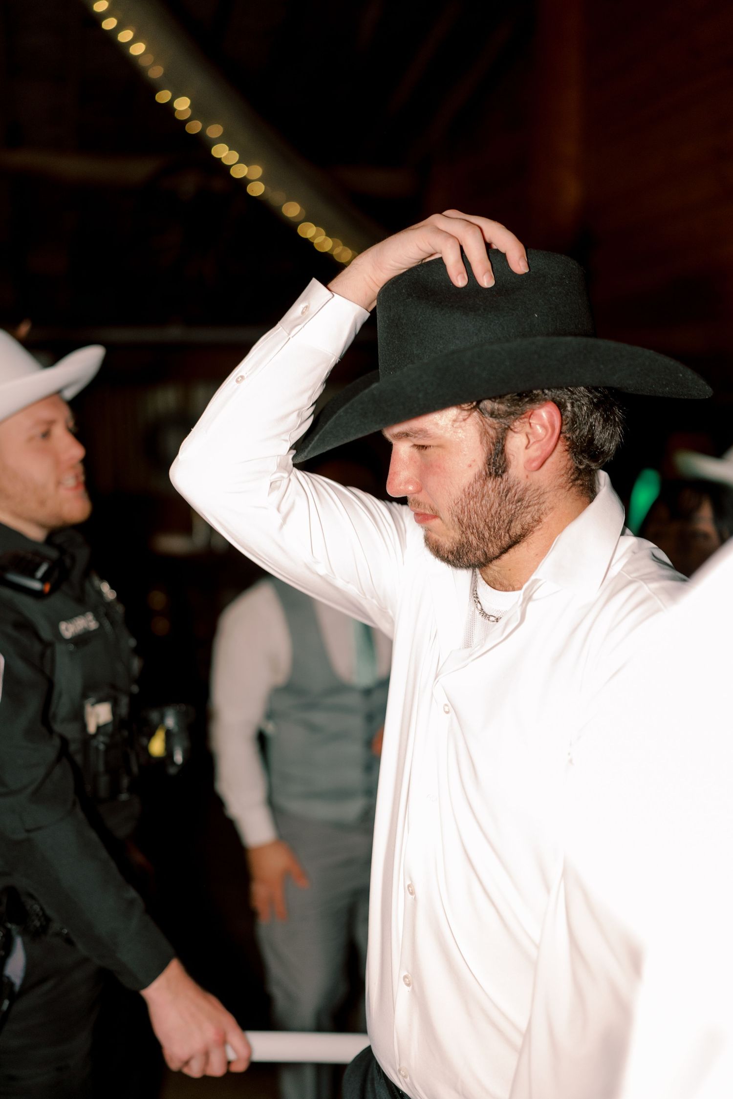 Dancer in white shirt and cowboy hat performing at a western-themed celebration.