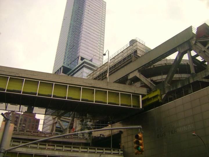 Urban elevated train tracks and transportation infrastructure against cloudy sky.