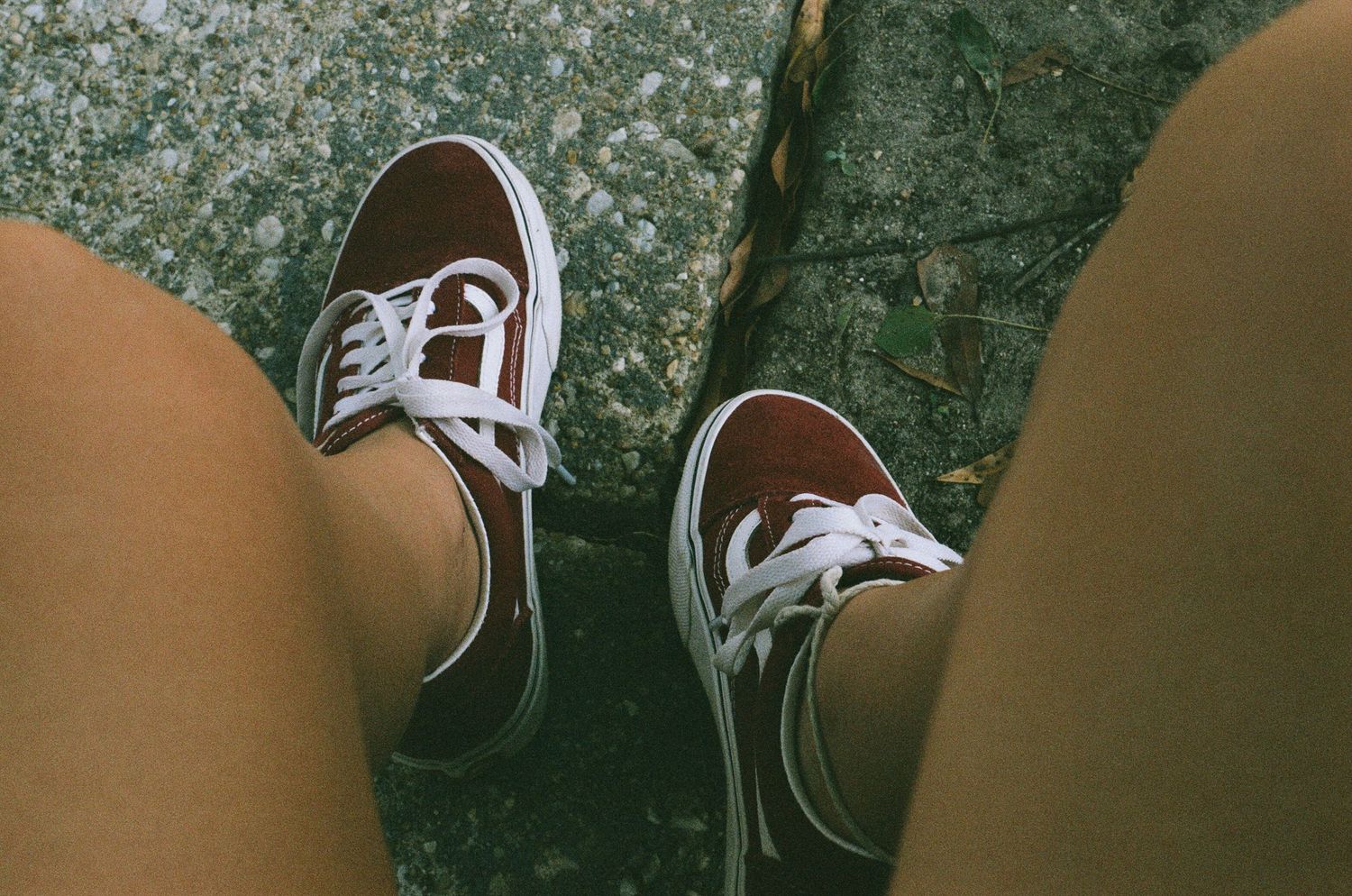 A pair of classic black and white sneakers on a wooden surface.