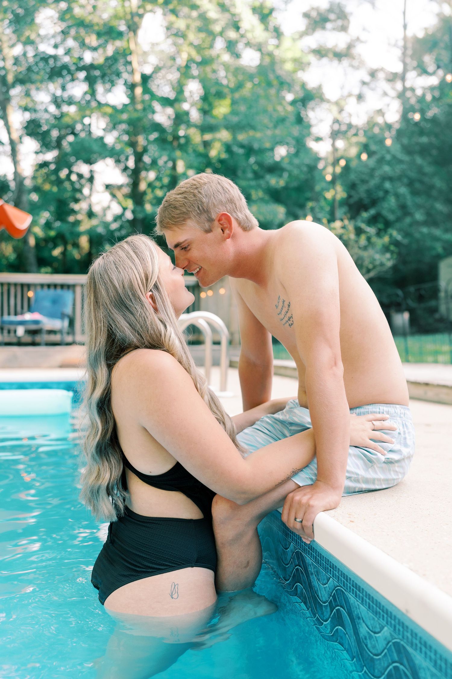 Romantic poolside engagement photos with couple sharing tender moments.