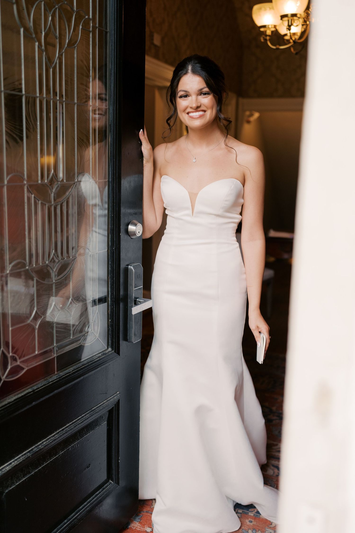 Elegant white wedding dress displayed in a boutique window.