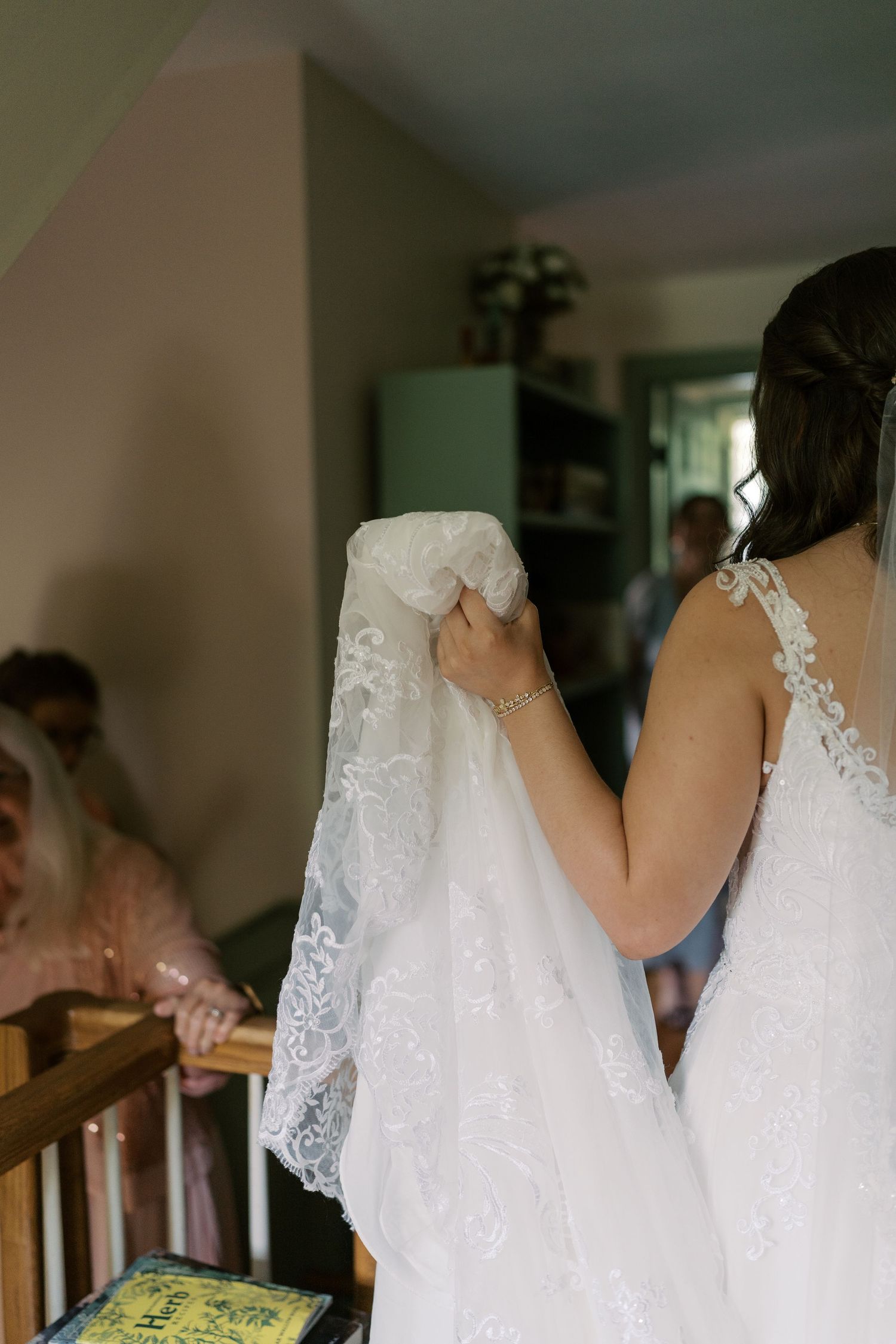 Delicate white lace wedding dress details hanging in preparation.