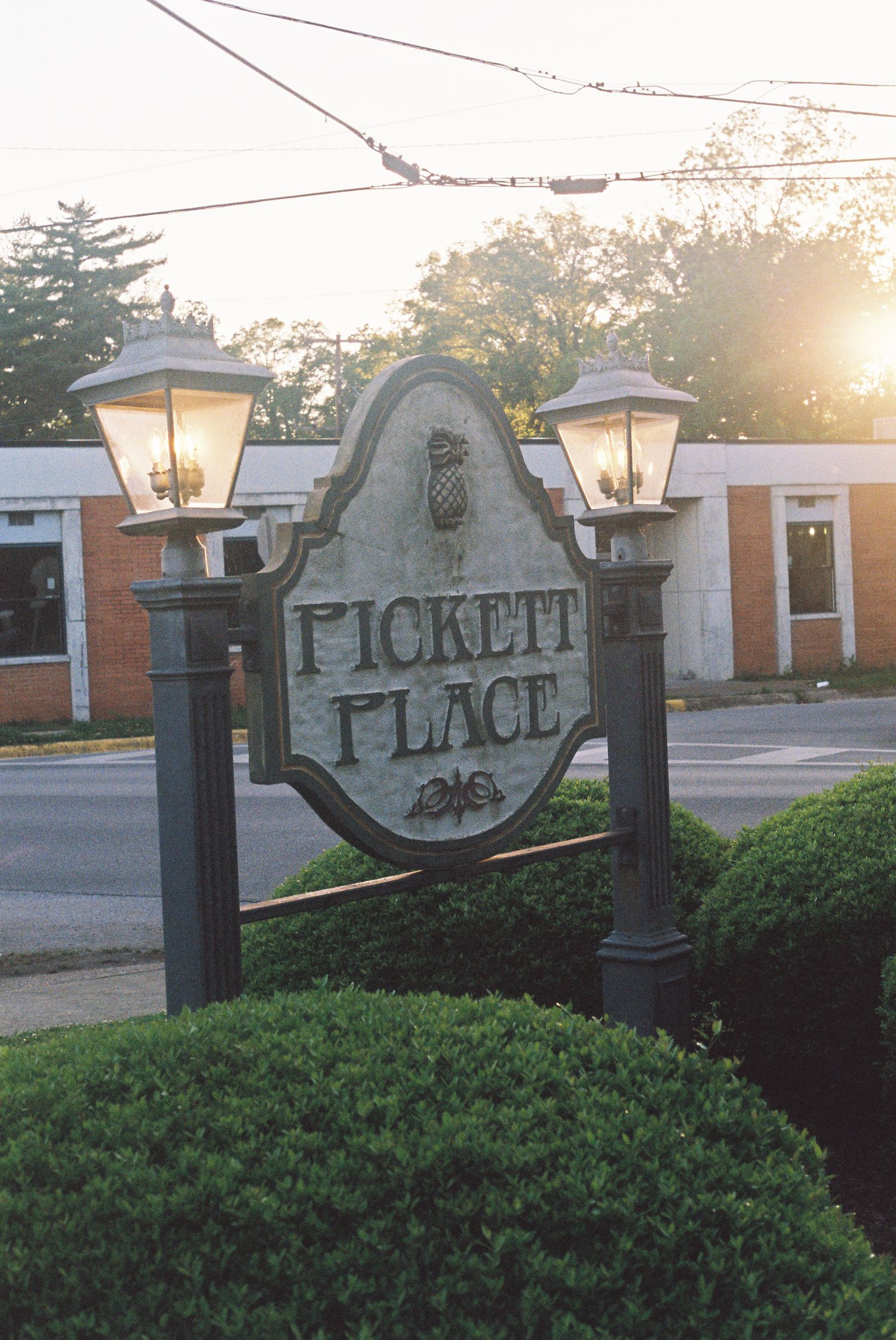 Stone entrance sign reading 'Pickett Place' with landscaping at dusk.