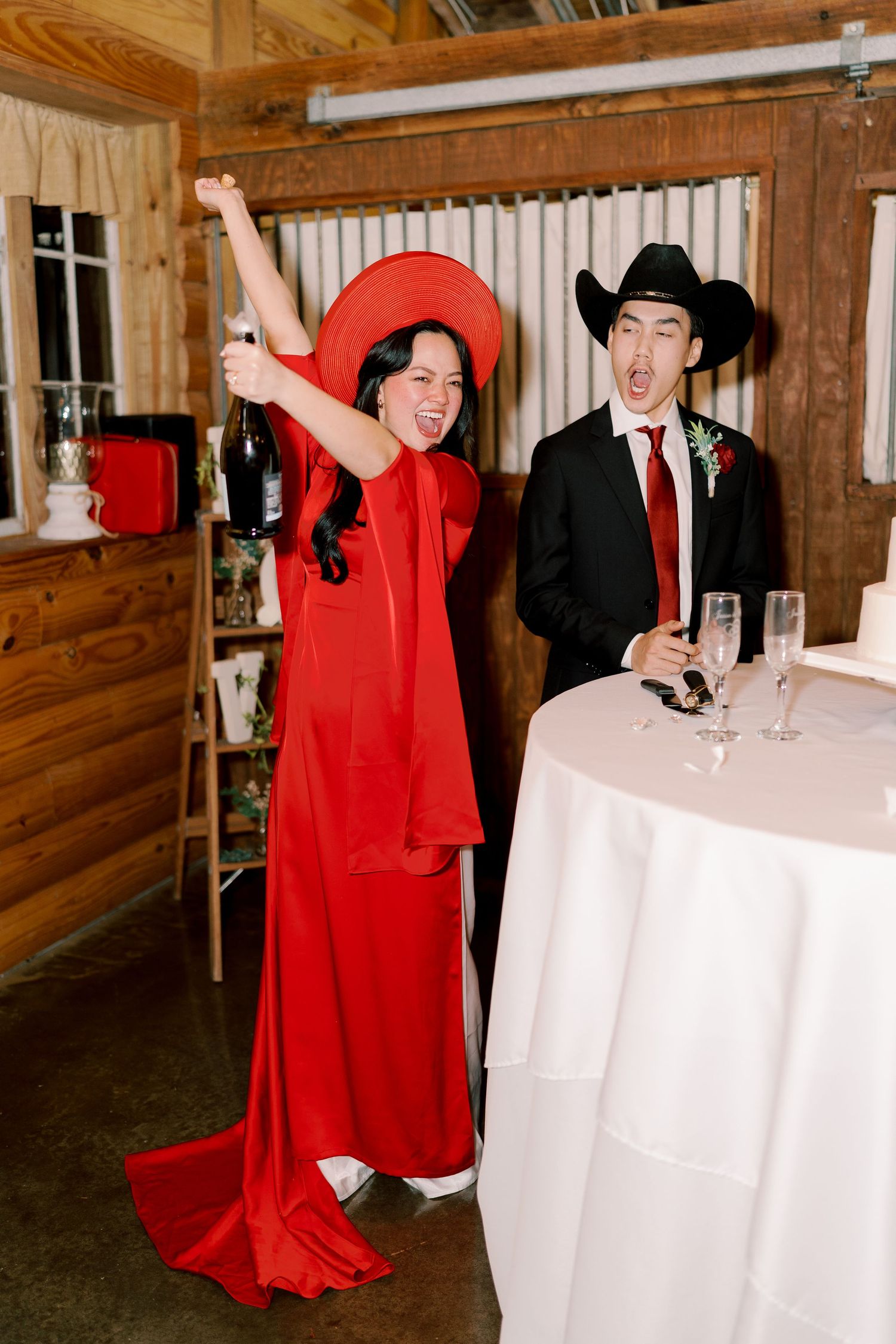 Wedding celebration with guests in red cloaks dancing around white reception tables.