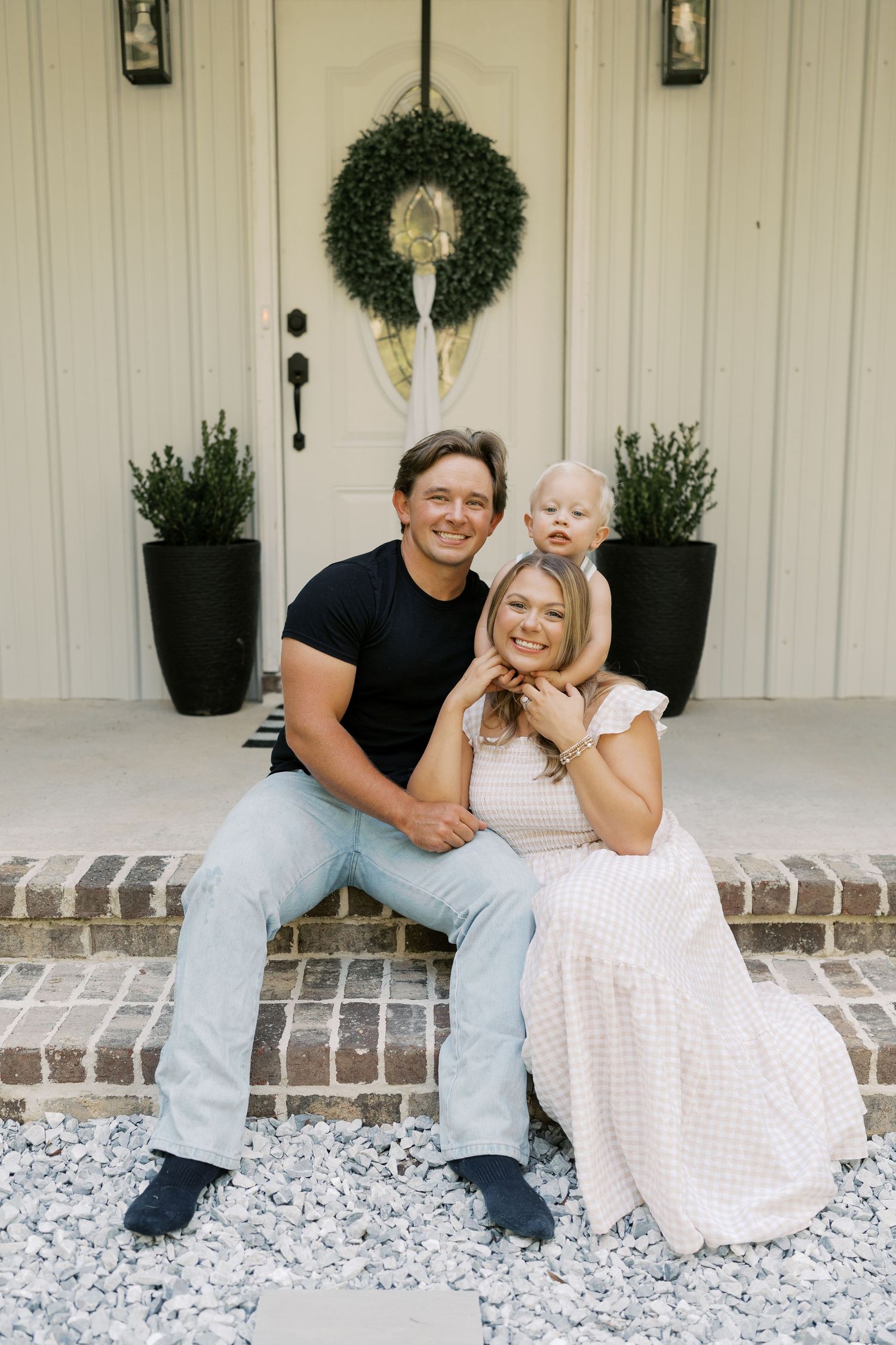 Family shares joyful moments while sitting on their front porch steps.