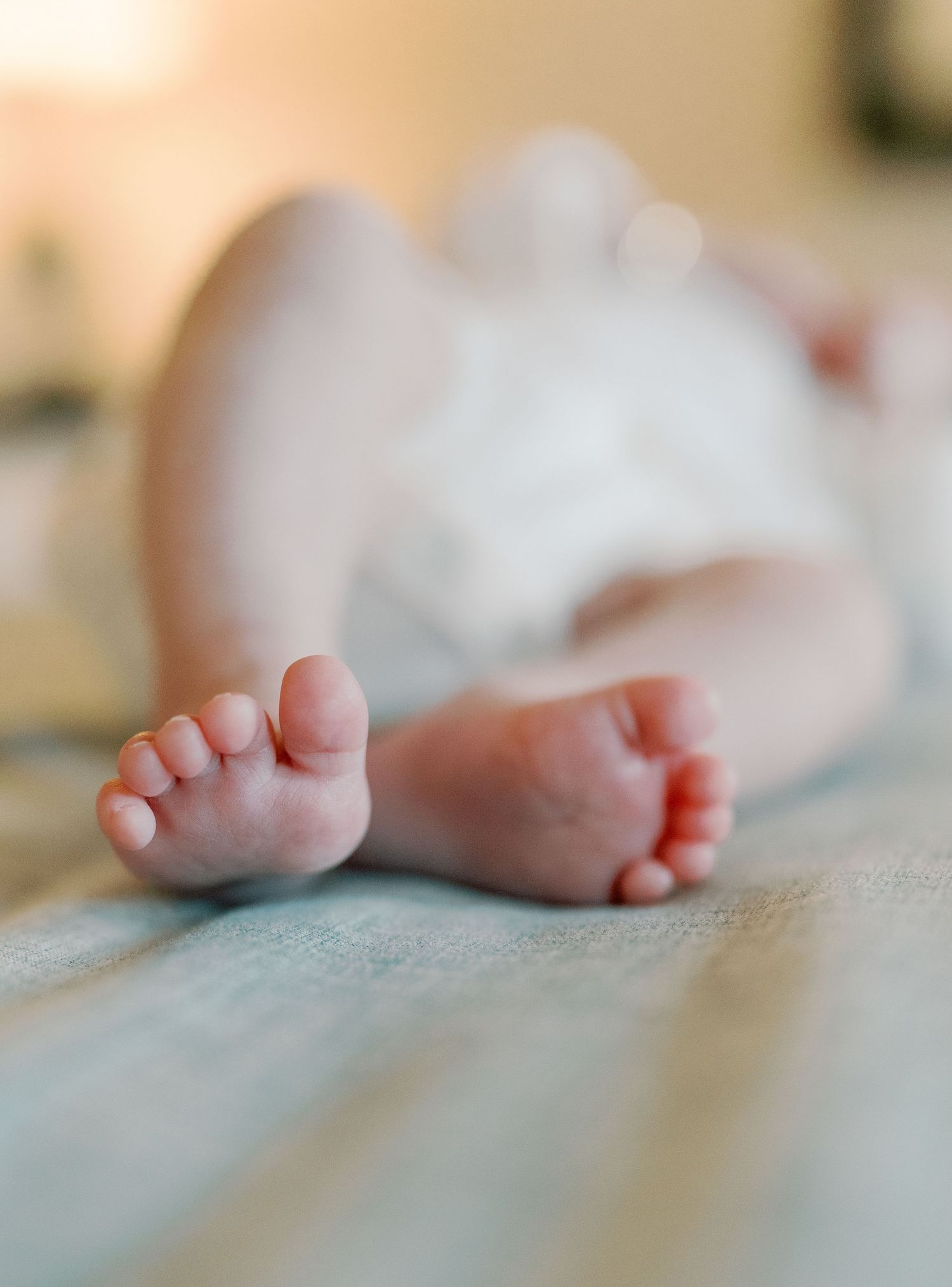 Close-up view of tiny baby feet resting on a textured surface.