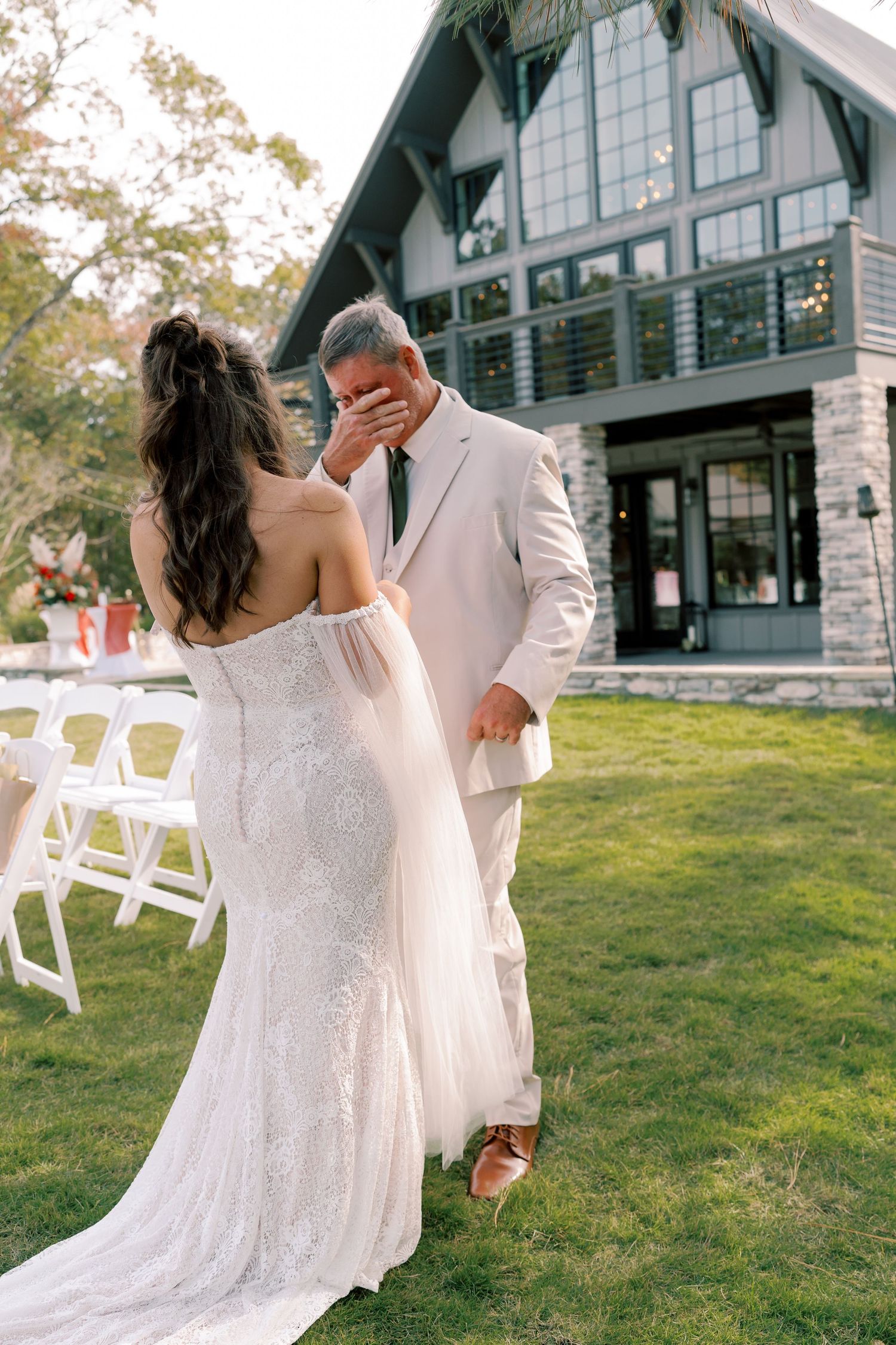 Romantic first dance moments captured outside a modern rustic venue with white chairs.