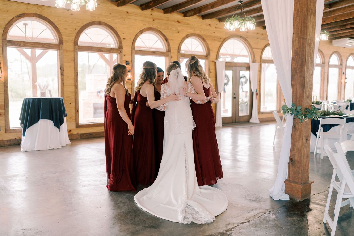 Elegant wedding reception venue with arched windows and rustic wooden beams.