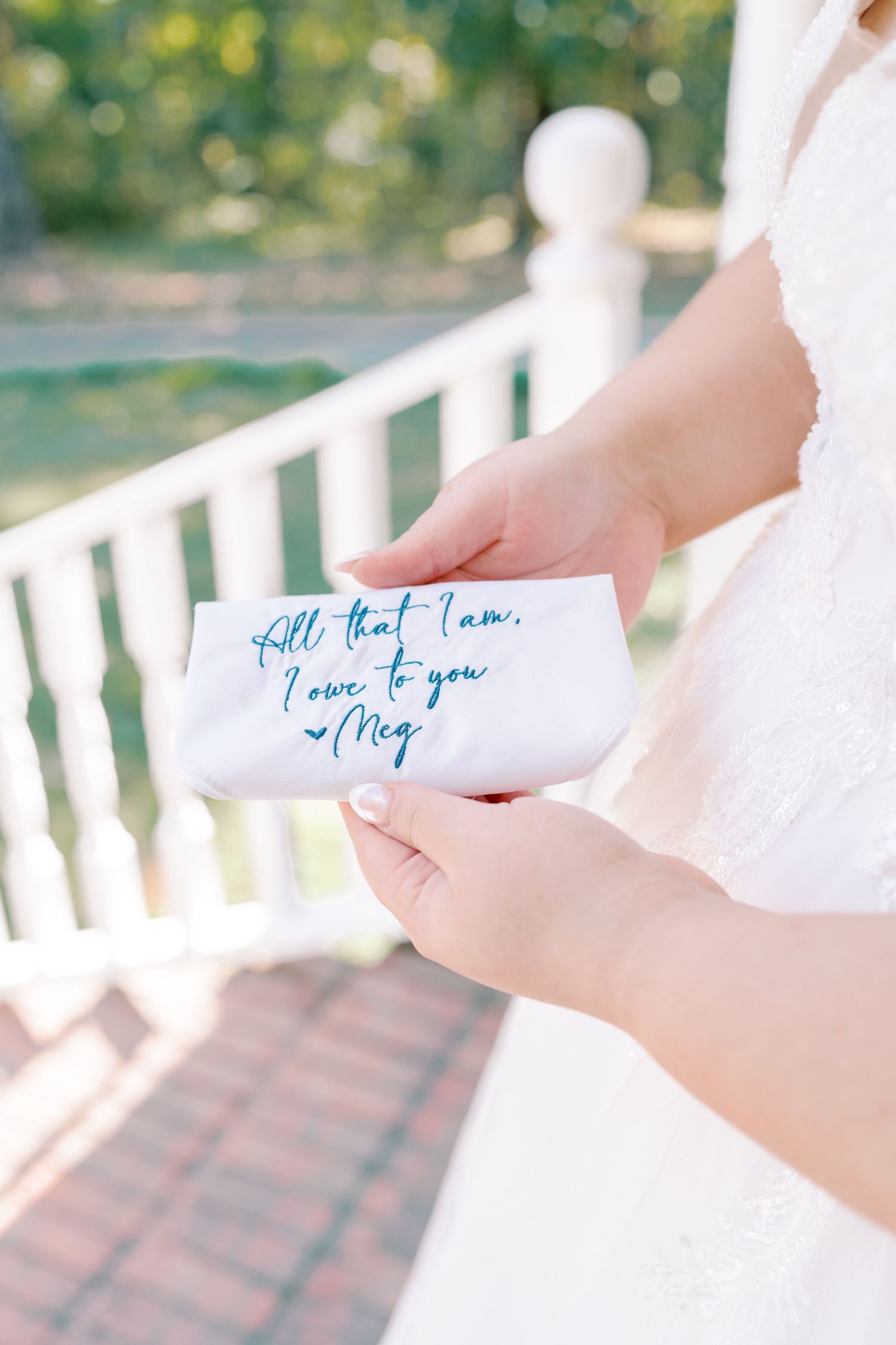 Hands holding delicate handwritten notes in blue ink against a white background.
