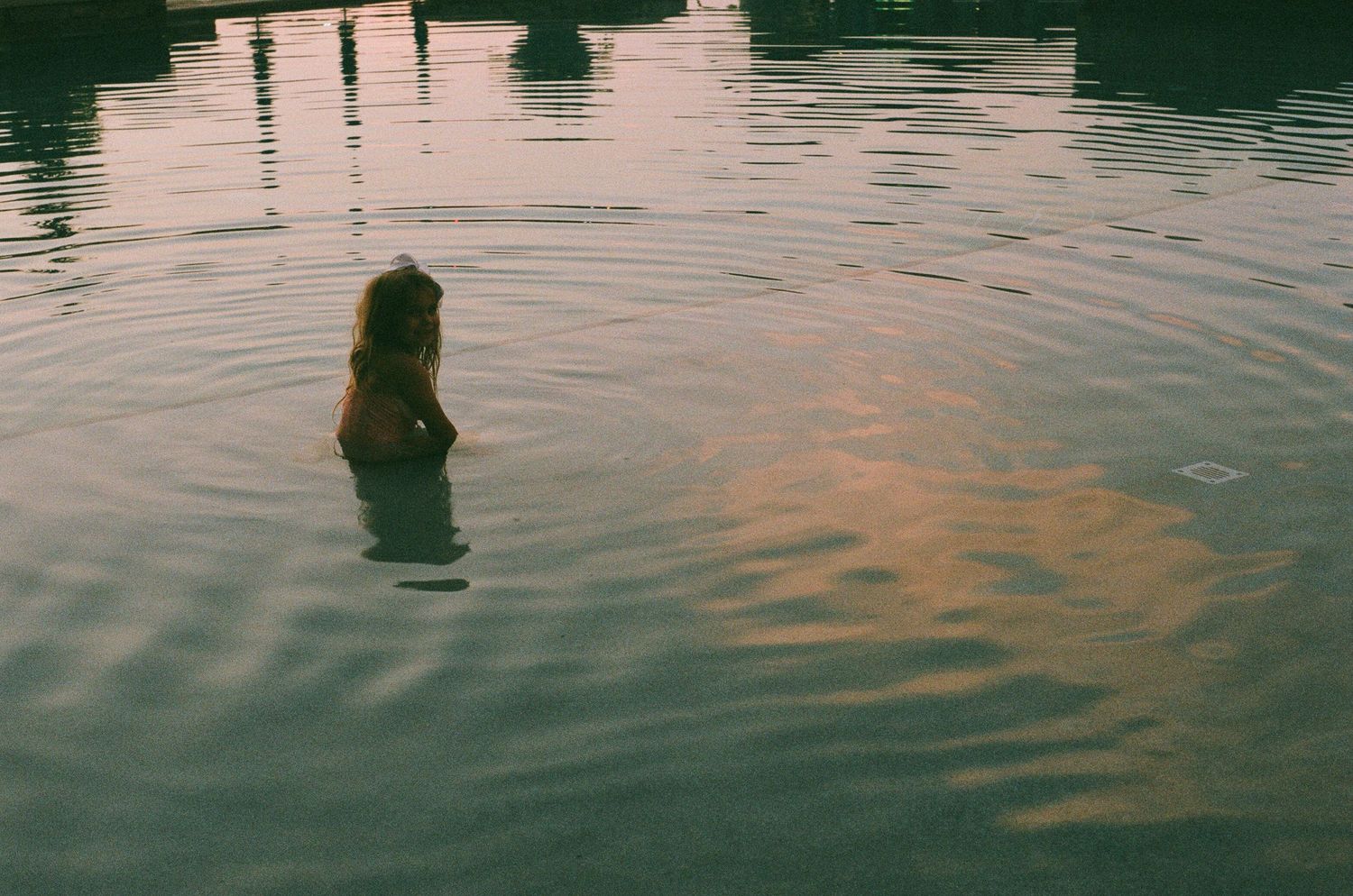 Calm water surface reflects light creating a serene rippled pattern at dusk.