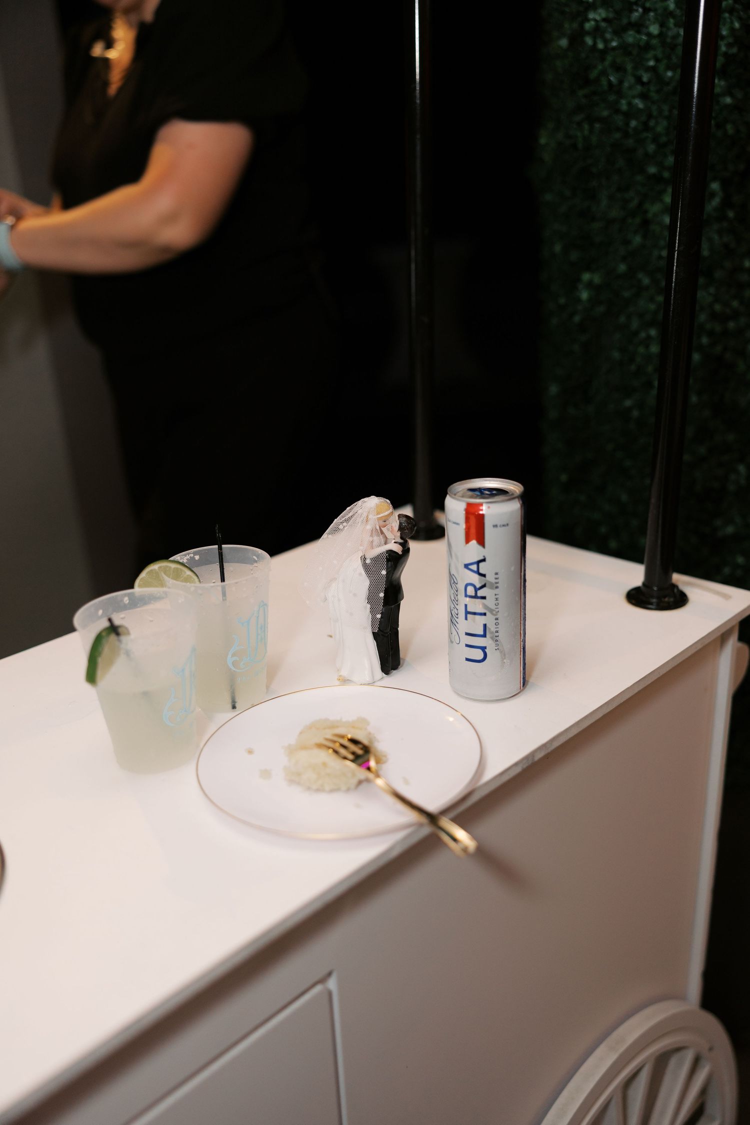 White reception bar setup with beverages and lime garnishes.
