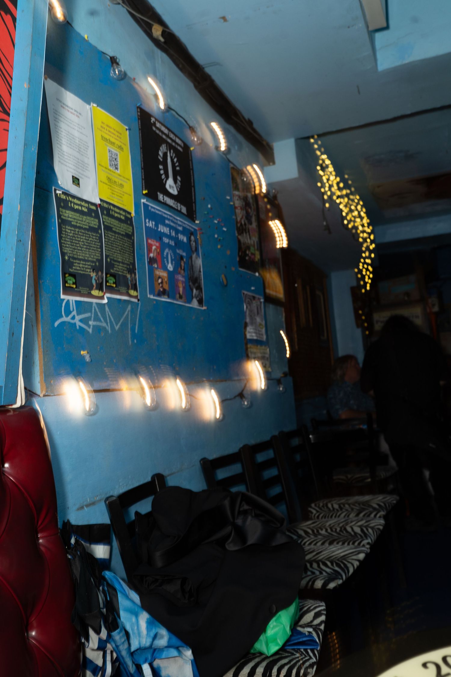 Blue walls with string lights and decorations in a dimly lit room.