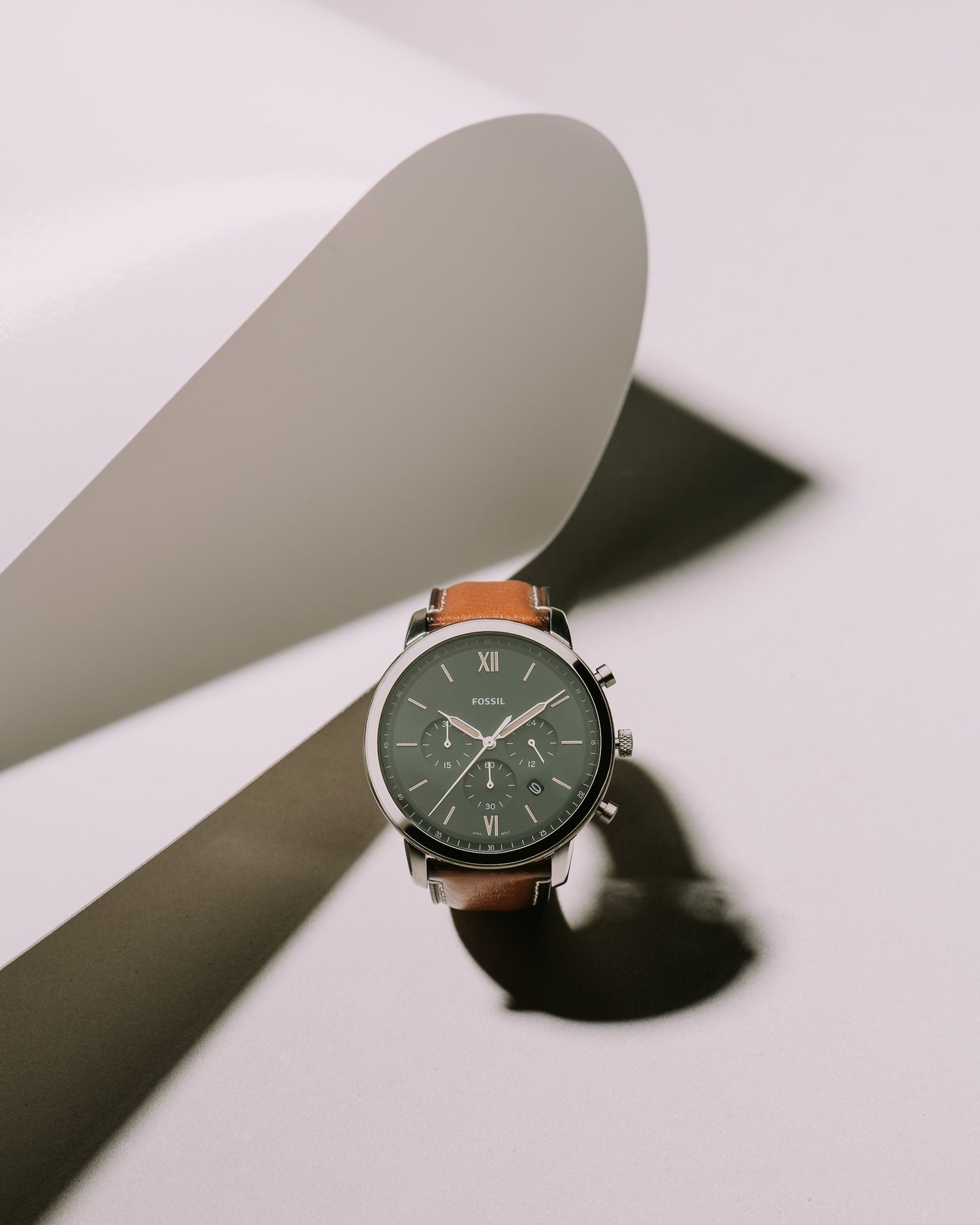 Fossil chronograph watch with green dial and tan leather strap on white background.