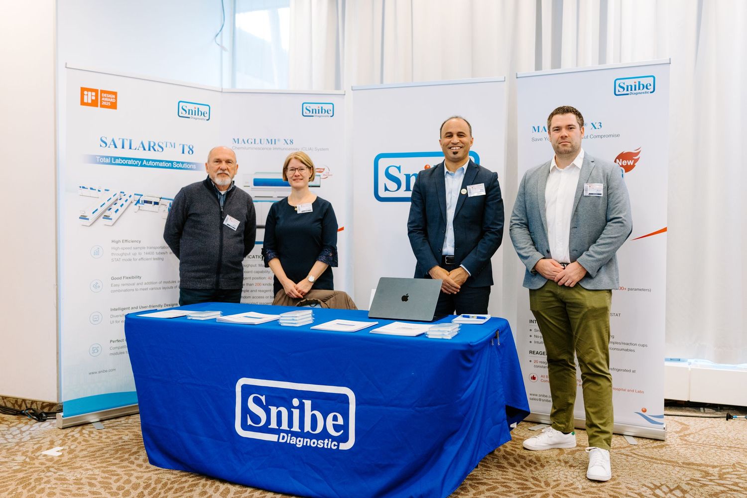Four professionals stand behind a Snibe Diagnostic branded table at a medical conference exhibition booth.