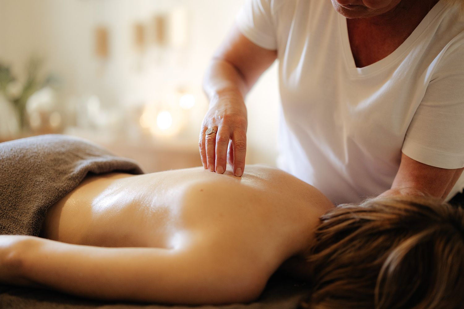 Massage therapist performing a relaxing back massage on a client in a spa setting.