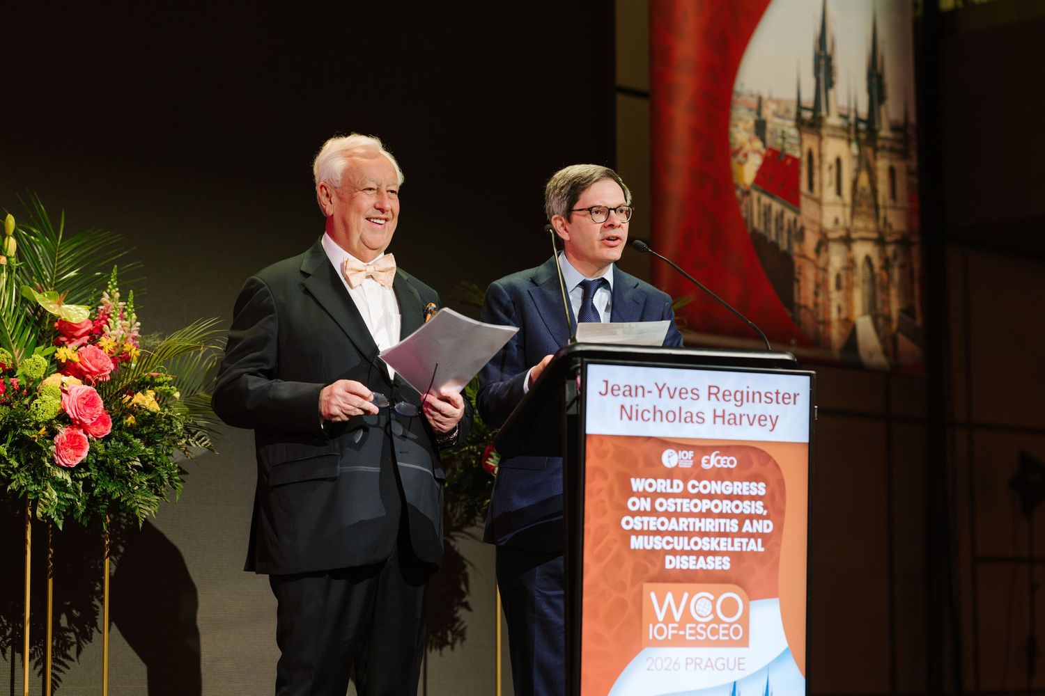 Two speakers Jean-Yves Reginster and Nicholas Harvey at WCO osteoporosis conference podium.