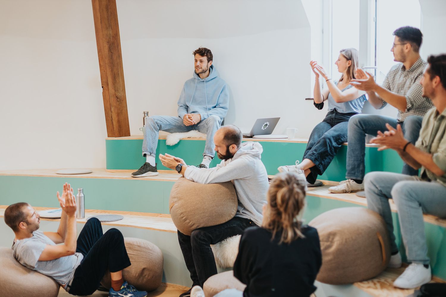 Diverse group of colleagues having an informal brainstorming meeting in a modern creative office space.
