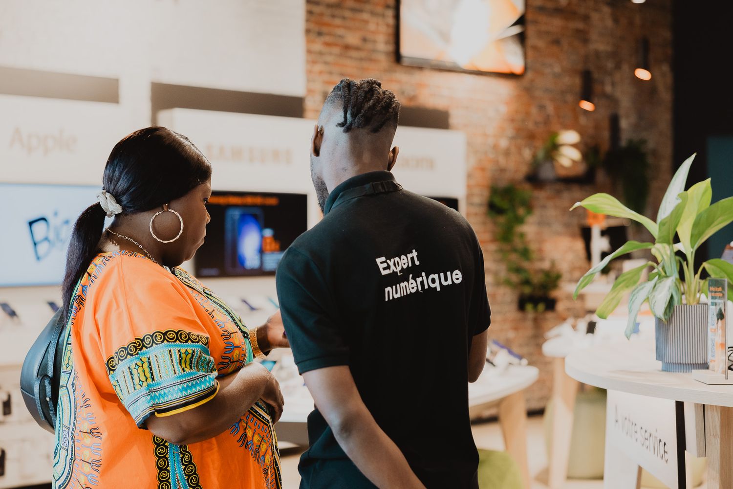 Digital expert assisting a customer in a modern electronics retail store.