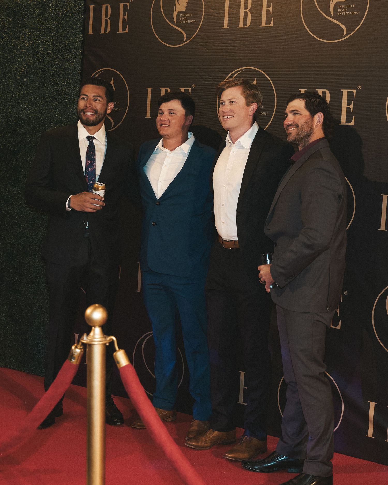 Group of friends posing together on the red carpet during a formal event or gala.