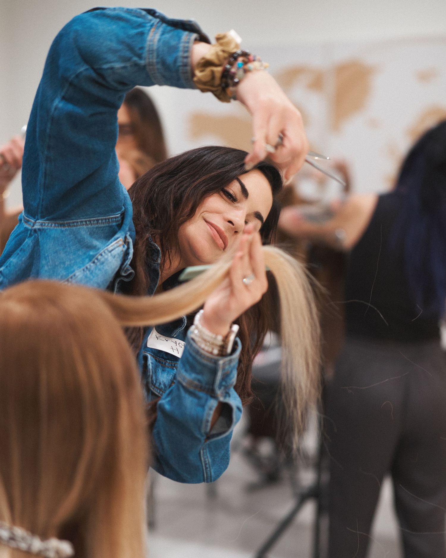 Attendee smiling while working on a model during a hands on education workshop with the class in the background