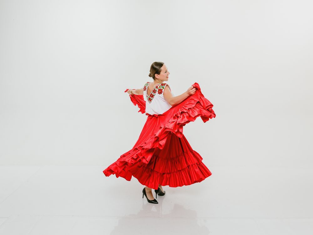 Lifestyle dance photography session in O’Fallon, Missouri. Girl Twirl in flowing red dress against white background in dynamic motion shots.