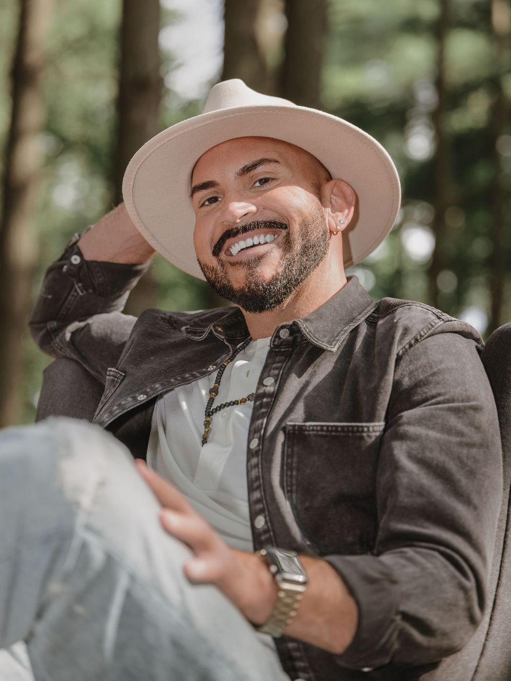 Branding photo session in St Charles, Missouri of Person in brown jacket and hat laughing while reclining outdoors, Bush Wildlife portraits.