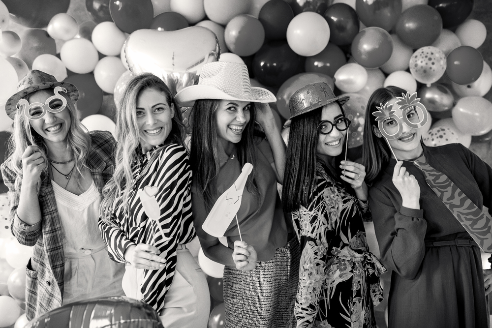 Open Air selfie Photo Booth in Saint Louis, Missouri with bachelorette party posing against black and white balloon arch backdrop.