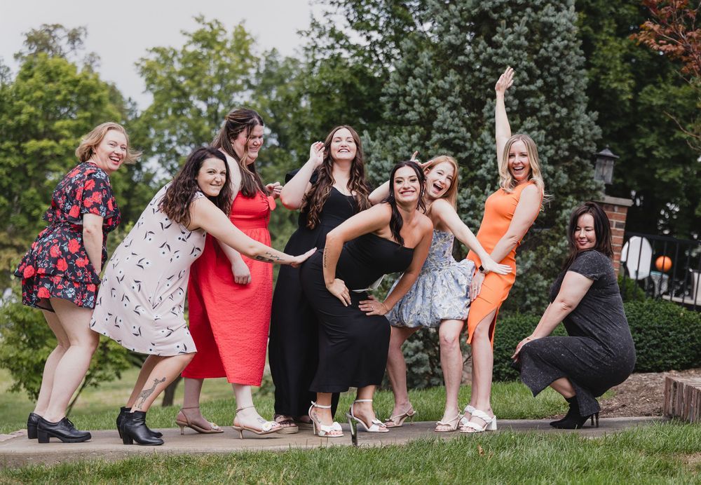 Lifestyle photography of group of friends pose playfully in a garden setting during a summer photoshoot in Saint Charles County.