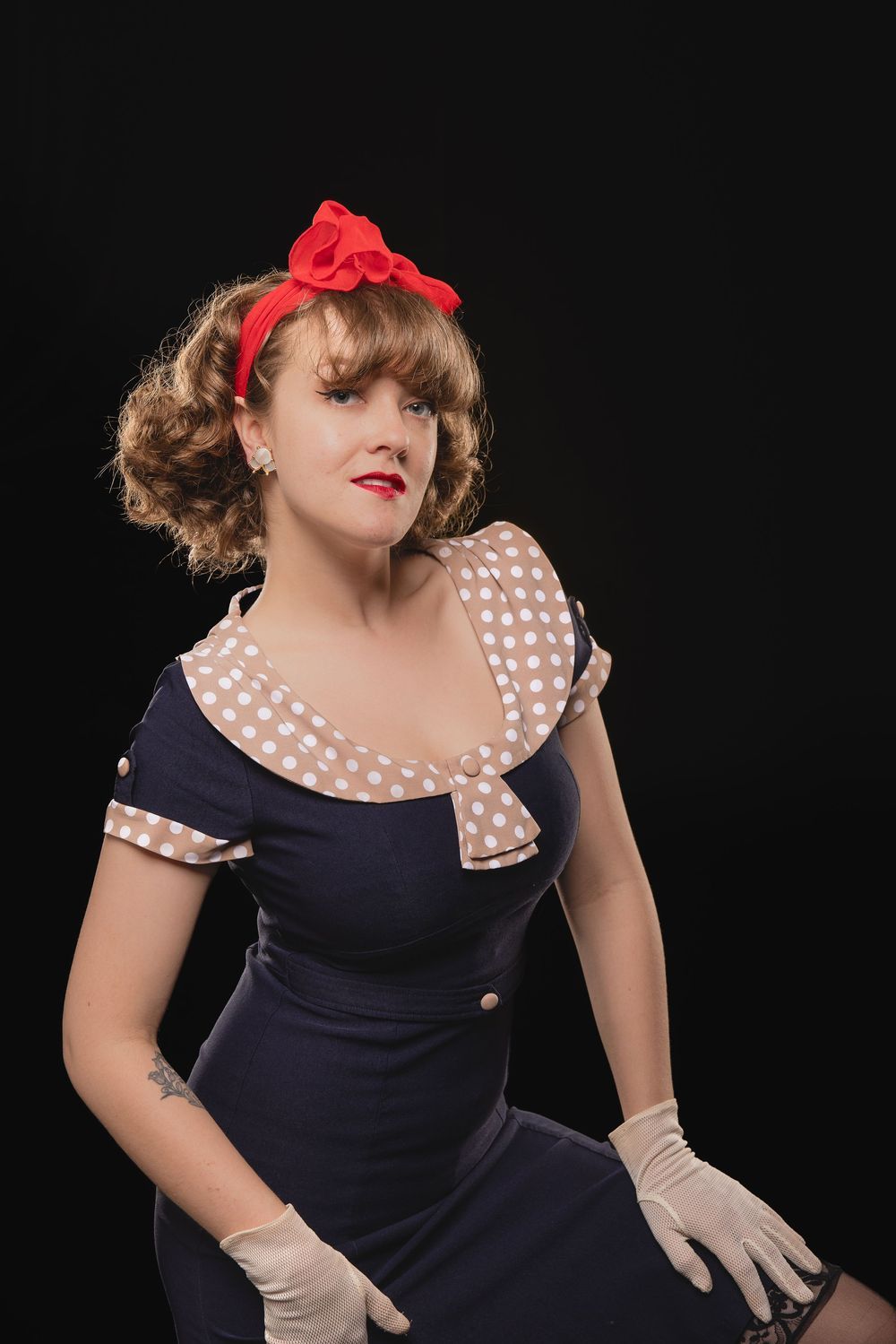 Model Call Photography in St Ann & OFallon MO with vintage style portraits of woman in polka dot dress and red bow against black background.