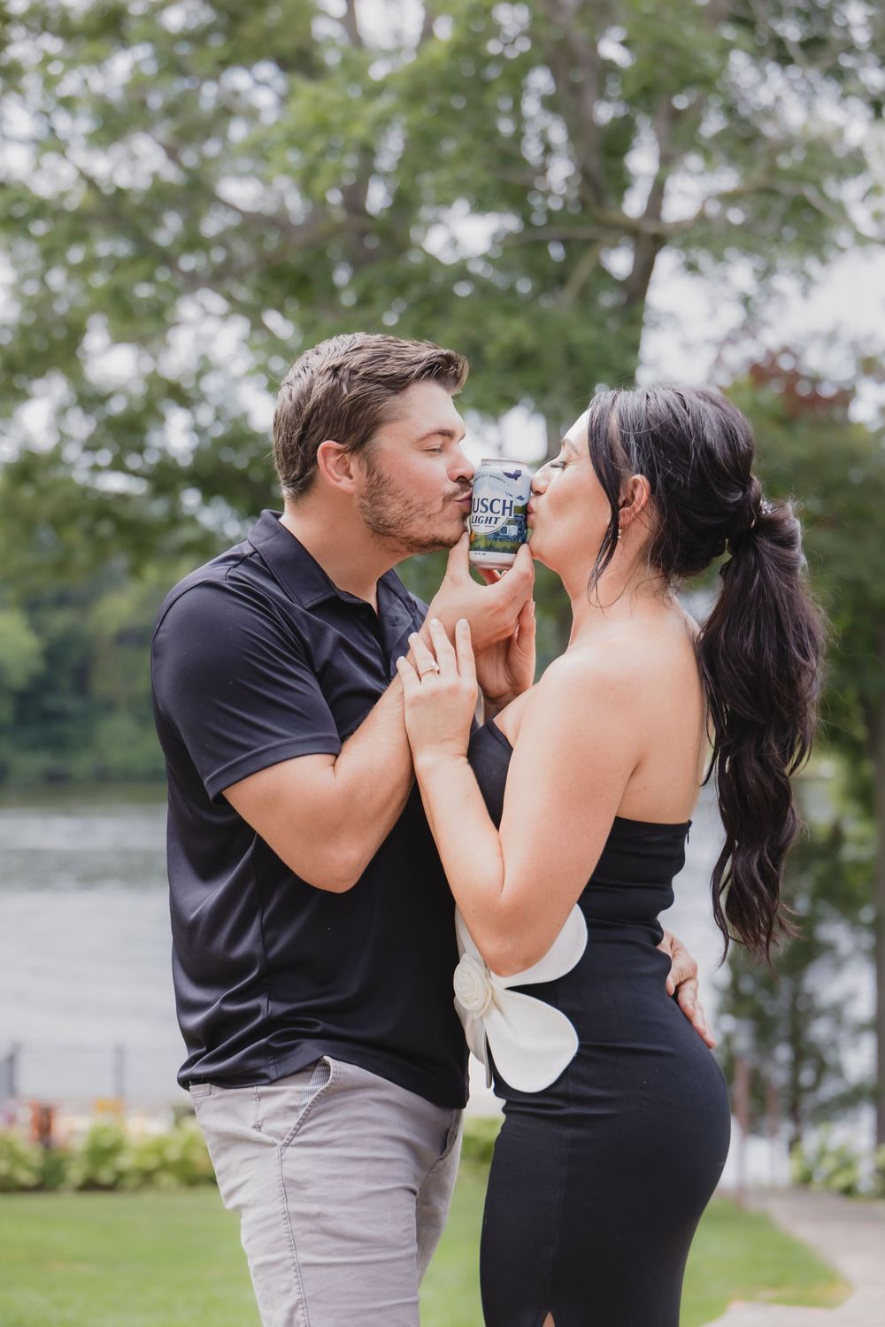 Couple photo session in Saint Charles County of a couple shares a drink together outdoors while wearing black and gray casual attire.